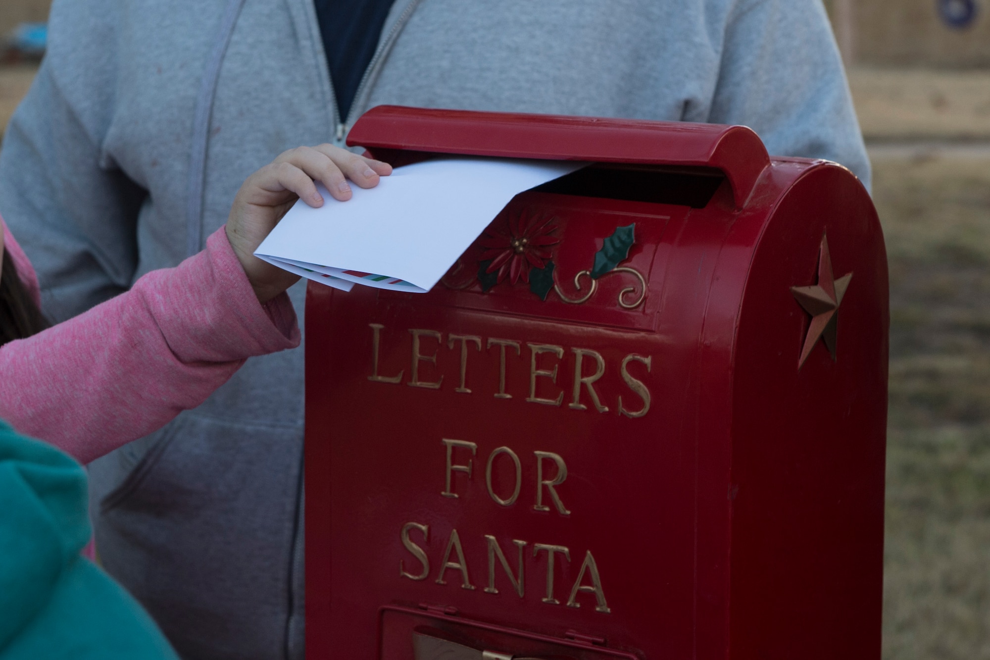 A member of the 97th Air Mobility Wing inserts a letter for Santa Claus into a mailbox during the Holiday Tree Lighting Event, Nov. 29, 2018, at Altus Air Force Base, Okla. Several different actives were set up for the Airmen of the 97th AMW and their families to celebrate the beginning of the holiday season. (U.S. Air Force photo by Senior Airman Cody Dowell)