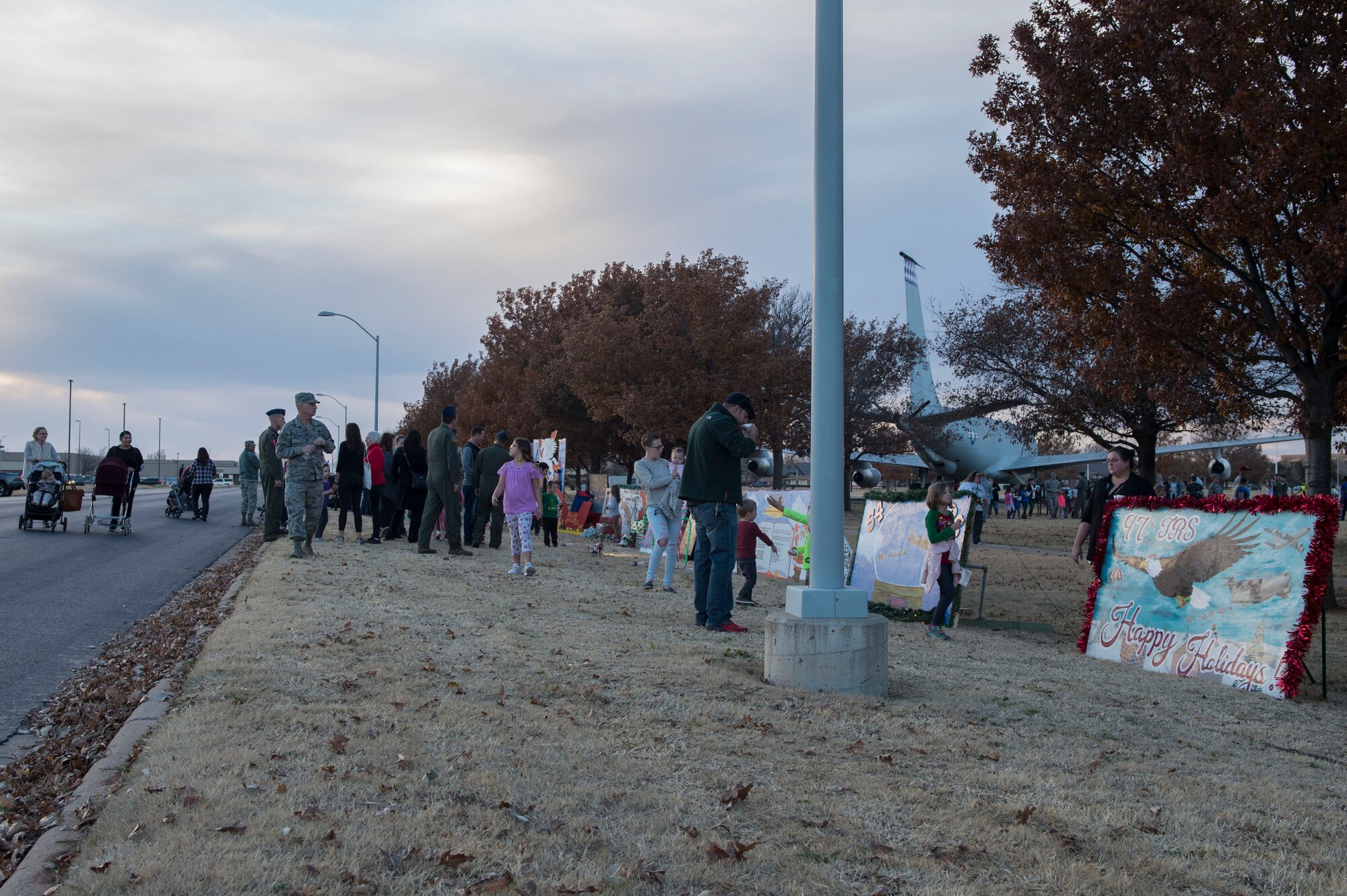 Members of the 97th Air Mobility Wing look at holiday cards created by several squadrons from the base during the Holiday Tree Lighting, Nov. 29, 2018, at Altus Air Force Base, Okla. Each squadron makes one card that will be showcased in Wings of Freedom Park for the entire month of December. (U.S. Air Force photo by Senior Airman Cody Dowell