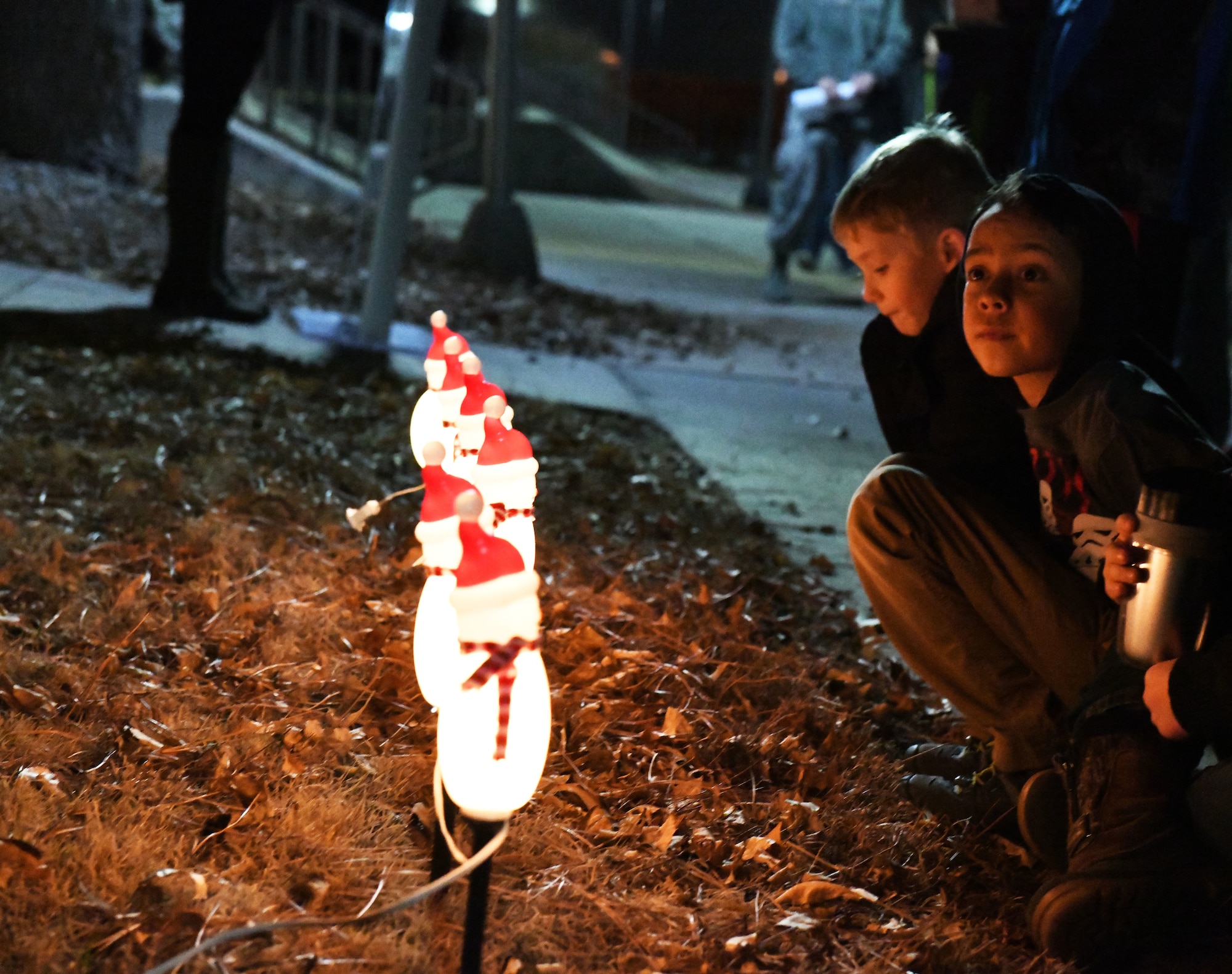 Children listen to a speech during a tree lighting ceremony at the Freedom Chapel on Ellsworth Air Force Base, S.D., Nov. 30, 2018. Airmen and their families came out to celebrate the lighting of the base tree and to start the holidays in a festive and family-friendly environment where multiple religions were represented. (U.S. Air Force photo by Airman 1st Class Thomas Karol)