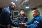 WATERS SOUTH OF JAPAN (Dec. 4, 2018) Cmdr. Leroy Mitchell, commanding officer of the Arleigh Burke-class guided-missile destroyer USS Benfold (DDG 65), greets Japan Maritime Self-Defense Force (JMSDF) Chief Operations Specialist Hideki Okubo, assigned to the JMSDF destroyer JS Hyuga (DDH-181), in the captain’s cabin during a tour aboard Benfold. Benfold is forward-deployed to the U.S. 7th Fleet area of operations in support of security and stability in the Indo-Pacific region.