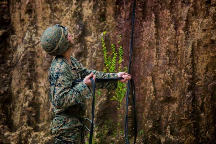 Cpl. Jonathon Cameron belays a Marine down a cliff Dec. 4, 2018 at Jungle Warfare Training Center, Camp Gonsalves, Okinawa, Japan. Marines with 9th Engineer Support Battalion, 3rd Marine Logistics Group, took part in the Basic Jungle Skills Course which includes patrolling, repelling, land navigation and an endurance course. Belaying is the action of guiding Marines as they repel down steep hills and cliffs. Cameron, a combat engineer with Bravo Company, 9th ESB, 3rd MLG, is a native of Arlington, Texas. (U.S. Marine Corps photo by Lance Cpl. Mark Fike)