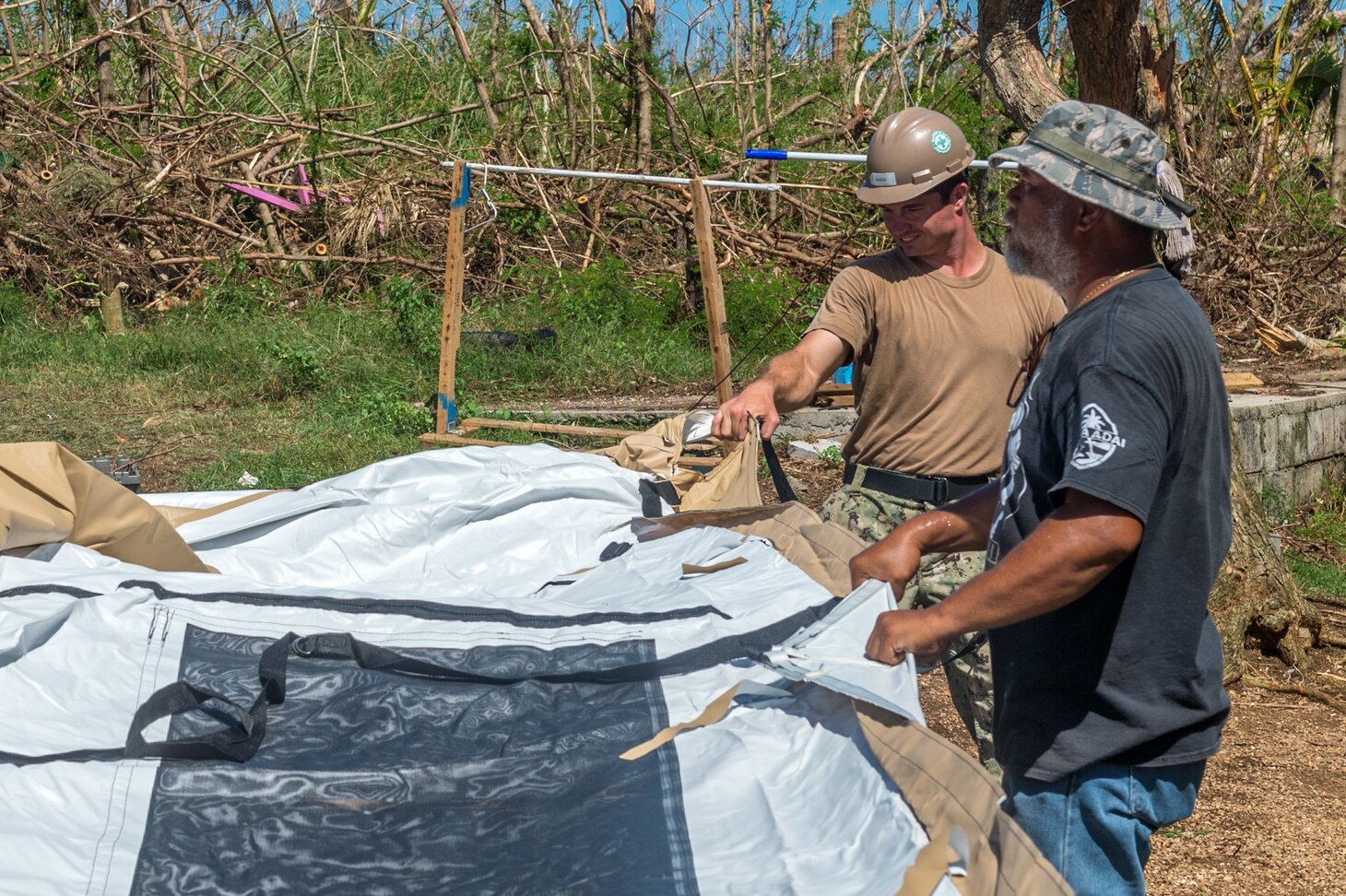 Commonwealth of the Northern Marianas Islands (Nov. 7, 2018) Builder Constructionman David Woods, assigned to Naval Mobile Construction Battalion 1, and a Tinian official erect a FEMA-provided tent for a Tinian family whose home was destroyed by Super Typhoon Yutu. Service members from Joint Region Marianas and Indo-Pacific Command are providing Department of Defense support to the Commonwealth of the Northern Mariana Islands' civil and local officials as part of the FEMA-supported Super Typhoon Yutu recovery efforts.