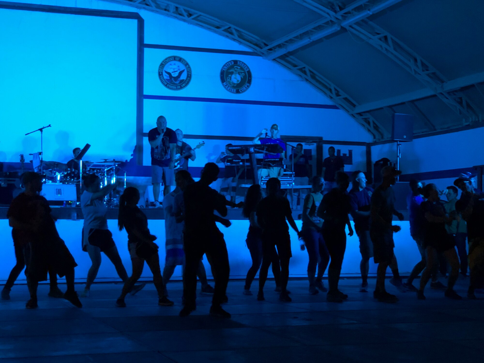 U.S. and Coalition members dance to music played by the U.S. Air Forces Central Command Band at an undisclosed location in Southwest Asia Aug. 19, 2018. The AFCENT Band has a mission to travel the U.S. Central Command area of responsibility to support and entertain deployed service members. (U.S. Air Force photo by Capt. Dustin Doyle)