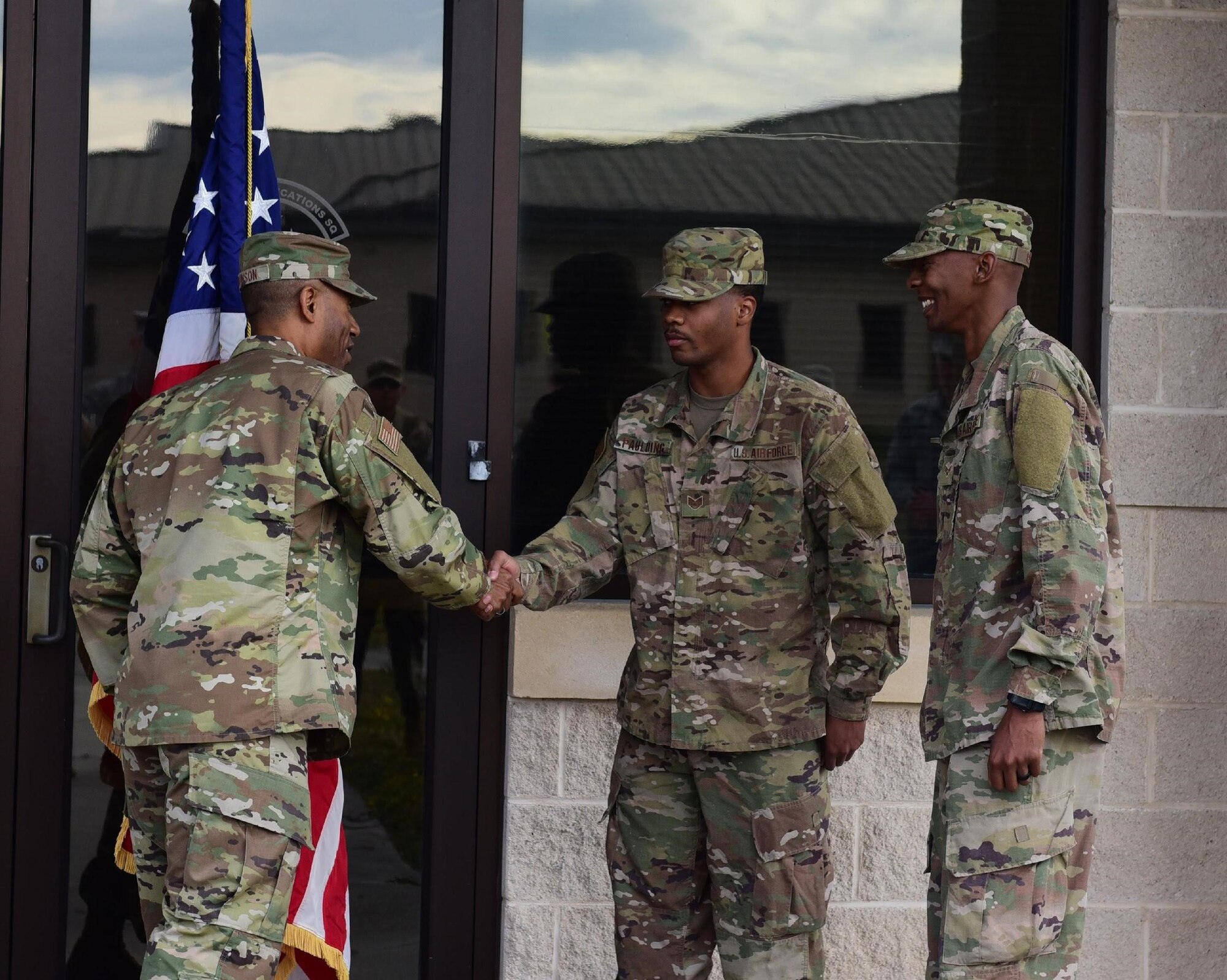 Air Force Maj. James Johnson, 325th Communication Squadron commander, congratulates Staff Sgt. Abrahm Paulding (center) and Senior Airman Antoine Brown (right), 325th CS cyber systems supervisors, on their re-enlistment at Tyndall Air Force Base, Fla., Nov. 30, 2018. The ceremony was the first to take place on Tyndall since Hurricane Michael hit in October. (U.S. Air Force photo by Senior Airman Cody R. Miller)