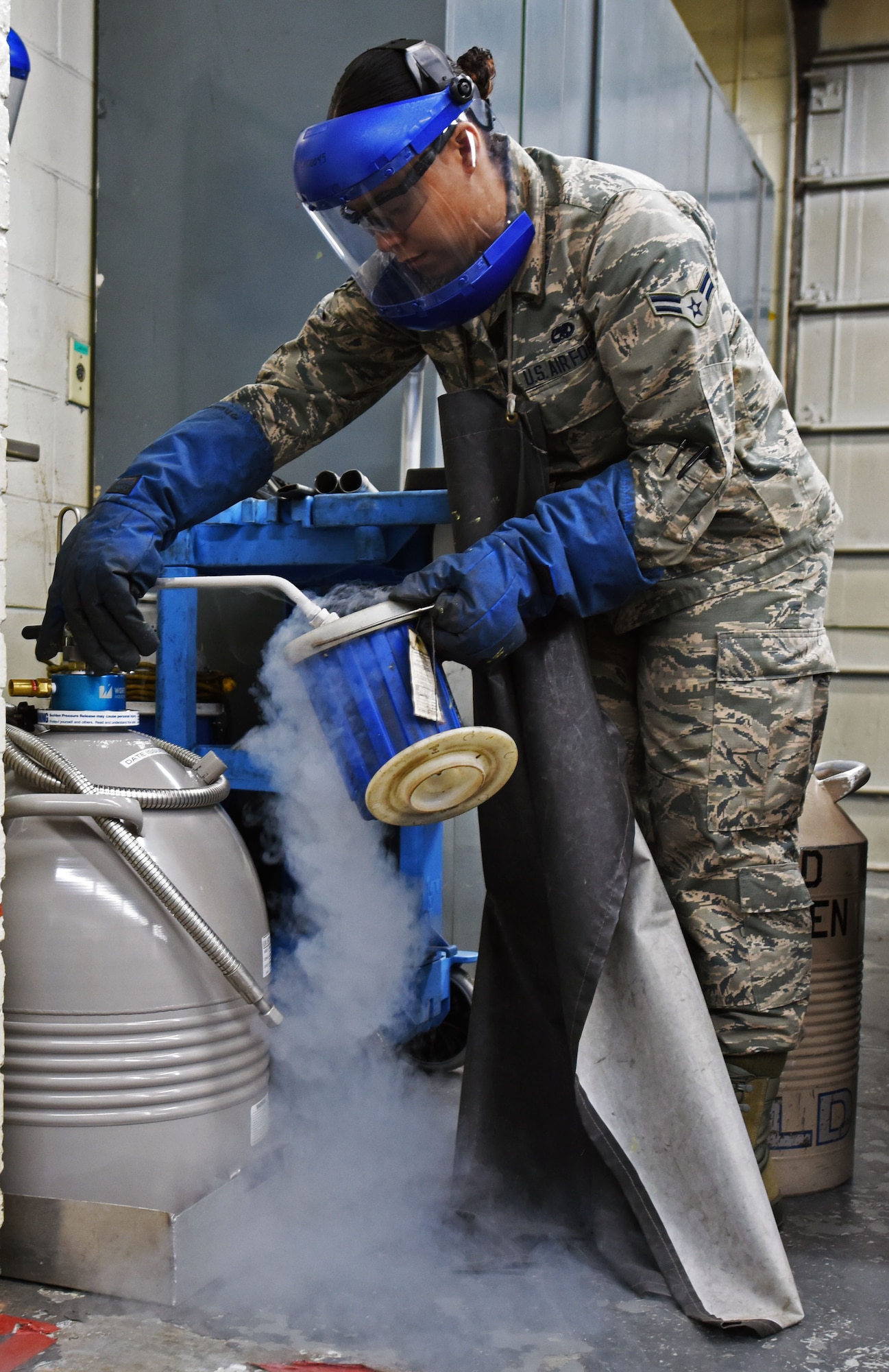 U.S. Air Force Airman 1st Class Sondra Saul, 20th Equipment Maintenance Squadron aircraft metals technician apprentice, fills a bucket with liquid nitrogen in the metal shop at Shaw Air Force Base, S.C., Nov. 30, 2018.