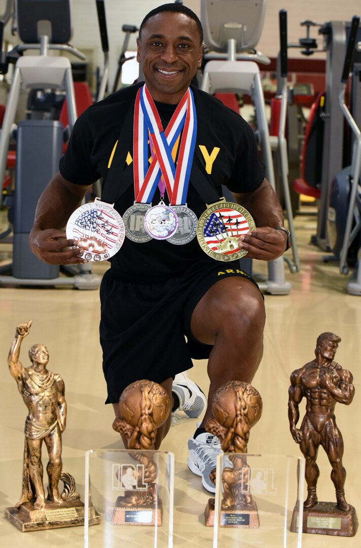 Army Capt. Johnny Dotson, displaying his award from the 2018 Drug Free Athletic Coalition World Championships, along with other medals he has won in bodybuilding competitions.
