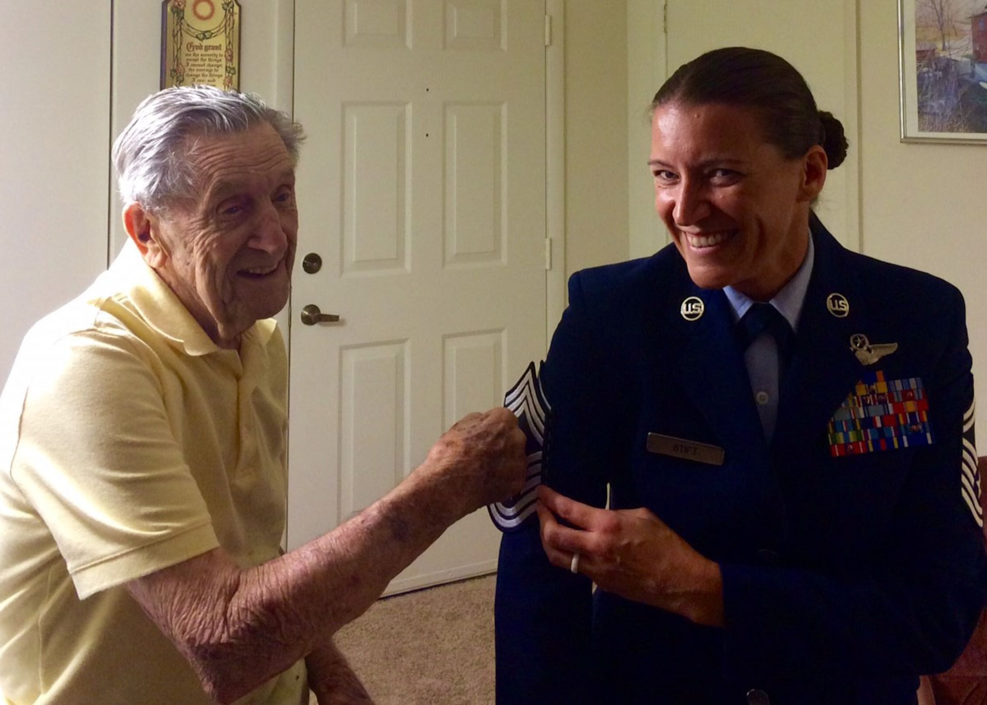 U.S. Air Force Lt. Col. (retired) Joseph S. Pesek, tacks chief master sergeant stripes onto his grandaughter Chief Master Sgt. Amanda J. Stift in 2015. Stift is the 403rd Wing command chief master sergeant and shares her grandfather's account of Dec. 7, 1941. Pesek is a World War II veteran who served in the U.S. Army Air Forces and U.S. Air Force. He was a technical sergeant stationed at Hickam Field, Hawaii, during the attack on Pearl Harbor. (Courtesy photo)