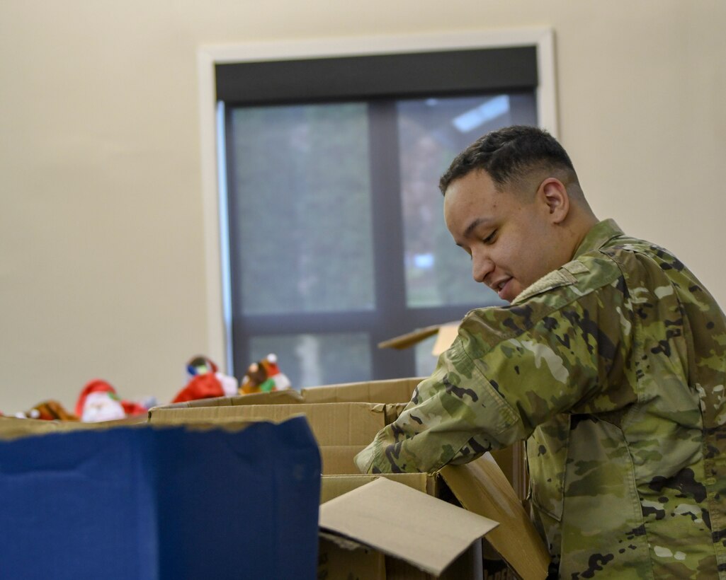 Staff Sgt. Brandon Simmons, a personnel helper with the 910th Mission Support Group, looks through boxes of donated toys for his two daughters in the Kubli Morale and Wellness Center at Youngstown Air Reserve Station, Dec. 1, 2018.