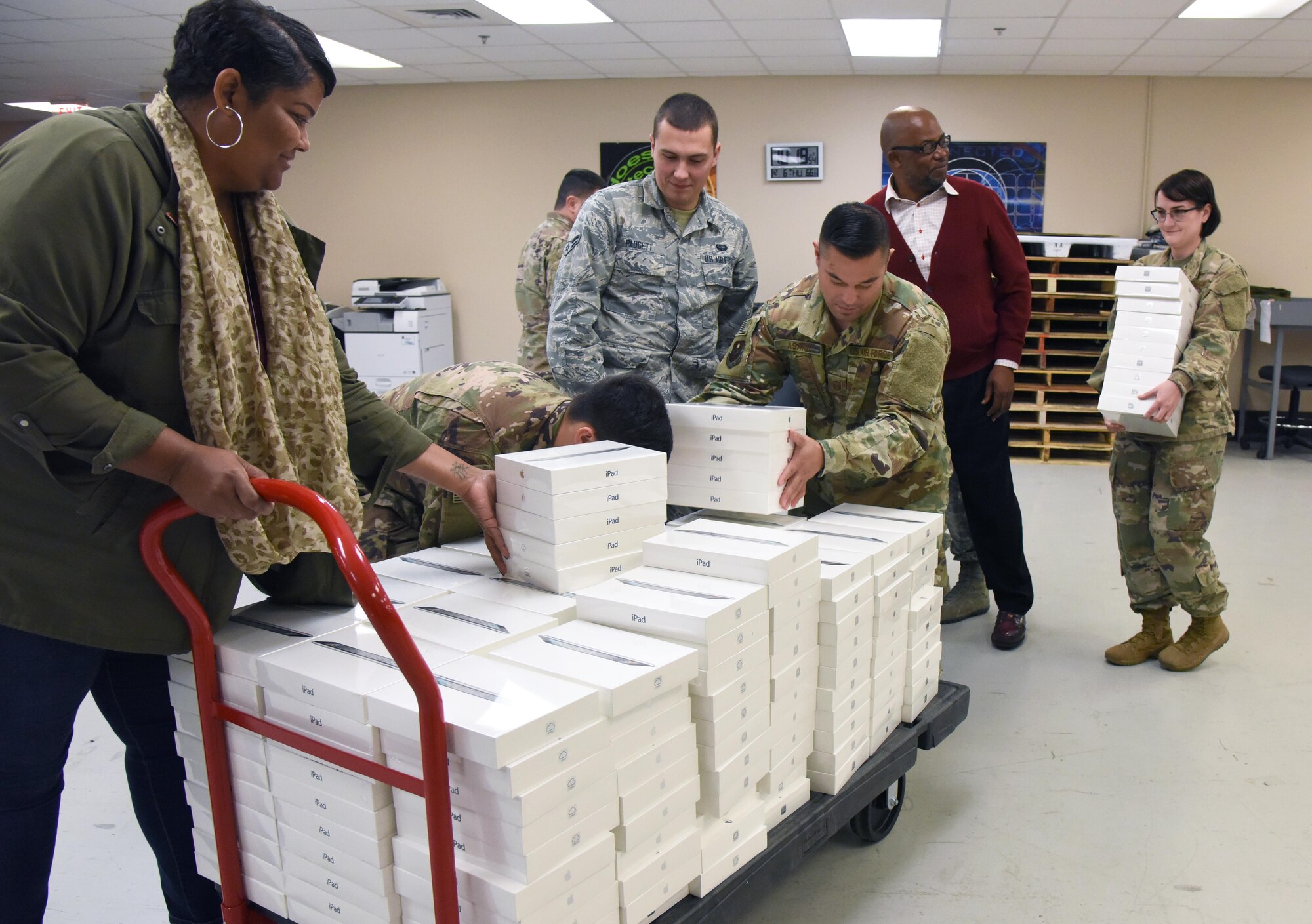 Members of the 81st Communications Squadron load 200 iPads at Keesler Air Force Base, Miss., Dec. 6, 2018. The 81st CS joined efforts with its honorary commander, Jade Ferguson, Mississippi Public Service Commission, Southern District district director, in identifying a school in need. Through this community partnership 200 iPads, valued at $72,000, were donated to the pre-kindergarten through second grade school for the opportunity of exploring science, technology, engineering, and mathematics (STEM). (U.S. Air Force photo by Kemberly Groue)