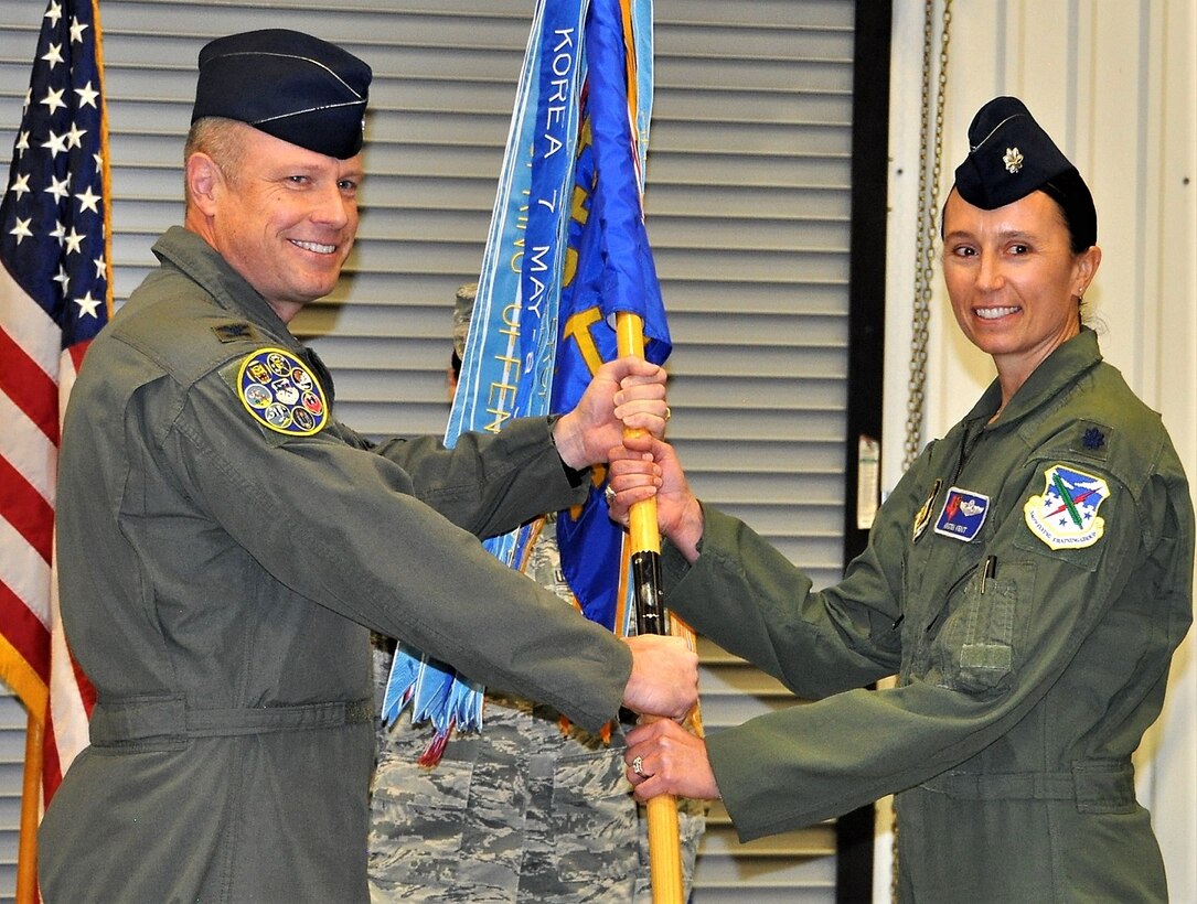 Lt. Col. Kristen Kent, right, accepts the 39th Flying Training Squadron guidon from Col. Allen Duckworth, 340th Flying Training Group commander, during an assumption-of-command ceremony held Dec. 6 at Joint Base San Antonio, Texas. (U.S. Air Force photo by Tech. Sgt. Brianne Blackstock)