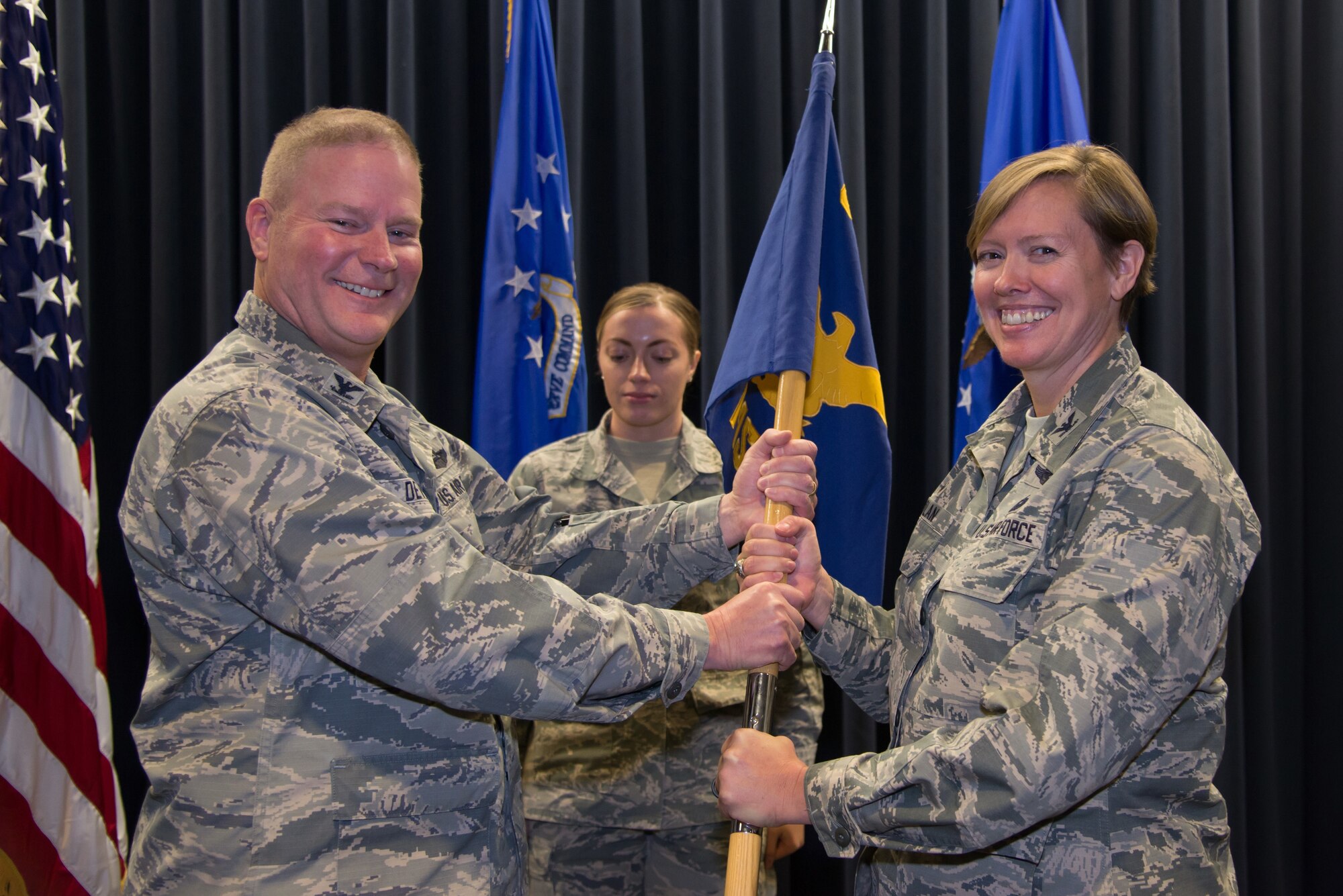 Col. James DeVere, the 302nd Airlift Wing commander, passes the 302nd Mission Support Group guidon to Col. Tara Nolan, the new 302nd MSG commander, during an assumption of command ceremony at Peterson Air Force Base, Dec. 1, 2018.