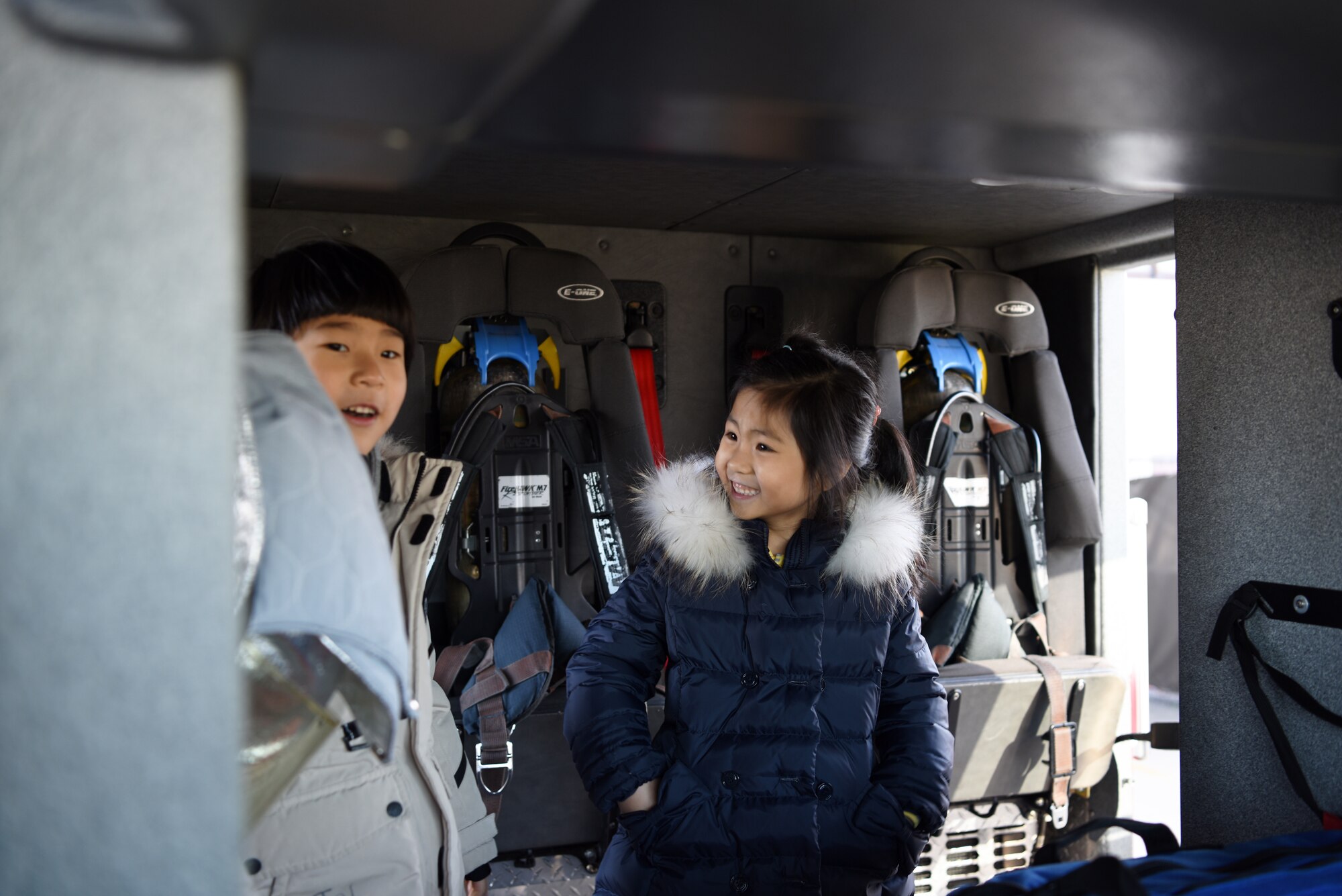 Jin-yong Jeong and Yun-seo Du, Korean Christian International School students, explore the back of a fire truck at Kunsan Air Base, Republic of Korea, Nov. 30, 2018. The Korean Christian International School came to base to tour the fire station and meet with firefighters. (U.S. Air Force photo by Staff Sgt. Joshua Edwards)