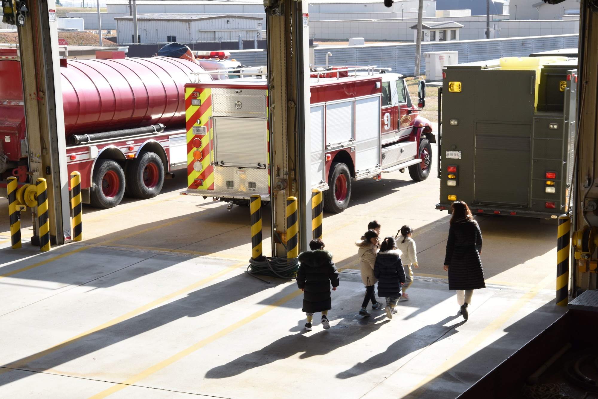 Korean Christian International School students and a teacher exit the 8th Civil Engineer Squadron fire house at Kunsan Air Base, Republic of Korea, Nov. 30, 2018. The students got the chance to explore several fire trucks and see firefighters live in action. (U.S. Air Force photo by Staff Sgt. Joshua Edwards)