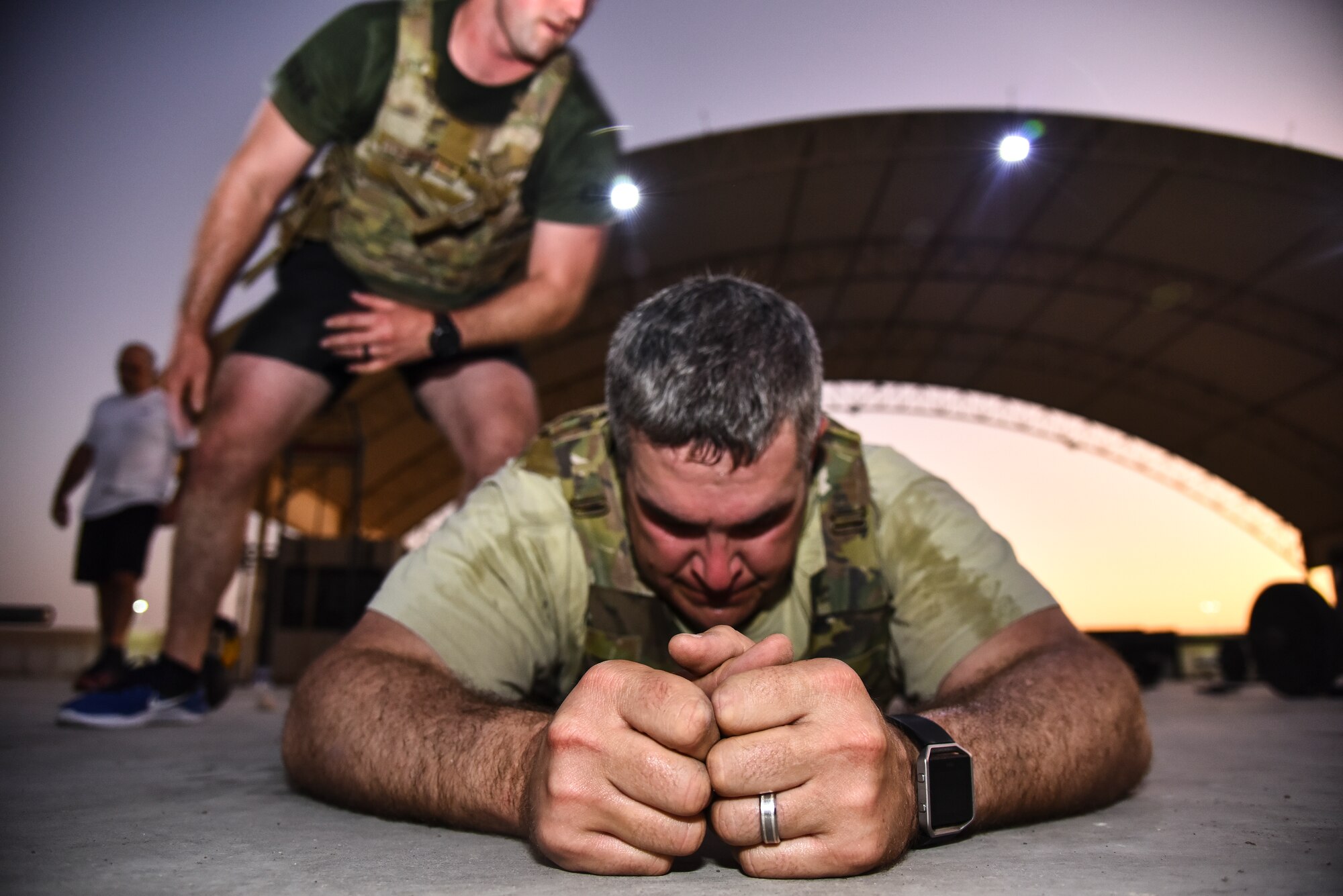 A U.S. Air Force Airman does burpees over his partner during the EOD 134 Memorial Workout at Al Dhafra Air Base, United Arab Emirates, Nov. 30, 2018. 380th Air Expeditionary Wing Airmen, along with coalition partners, participated in the workout to honor the 134 EOD technicians from the U.S. Air Force, Army, Navy and Marine Corps that have been killed since Sept. 11, 2001. (U.S. Air Force photo by Senior Airman Mya M. Crosby)