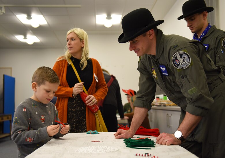 A guest of the 492nd Fighter Squadron Children’s Christmas Party performs some arts and crafts at the Duxford Imperial War Museum, Cambridge, England, Dec. 1, 2018. Around 50 members and spouses from the 492nd FS ‘Madhatters’ collaborated with the three charity organizations to help bring some extra joy this holiday season to children with serious or terminal illness or severe burns. (U.S. Air Force photo by Staff Sgt. Alex Fox Echols III)