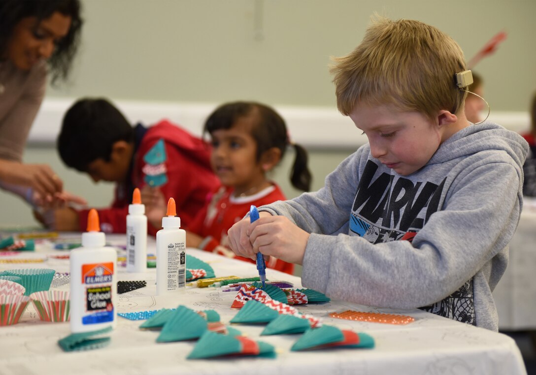 A guest of the 492nd Fighter Squadron Children’s Christmas Party creates a holiday display at the Duxford Imperial War Museum, Cambridge, England, Dec. 1, 2018. More than 100 children enjoyed carnival games, festive arts and crafts, pilot equipment displays, Morse code lessons, and a special visit and presents from Father Christmas himself. (U.S. Air Force photo by Staff Sgt. Alex Fox Echols III)