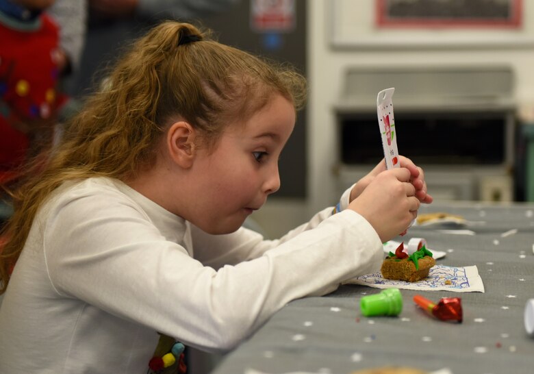 A guest of the 492nd Fighter Squadron Children’s Christmas Party decorates a cookie at the Duxford Imperial War Museum, Cambridge, England, Dec. 1, 2018. Around 50 members and spouses from the 492nd FS ‘Madhatters’ collaborated with the three charity organizations to help bring some extra joy this holiday season to children with serious or terminal illness or severe burns. (U.S. Air Force photo by Staff Sgt. Alex Fox Echols III)