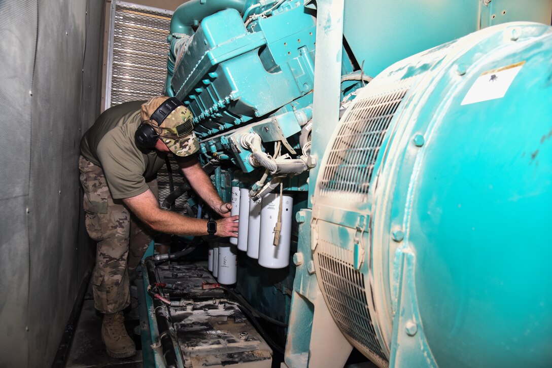 U.S. Air Force Staff Sgt. Tyler Muldowney, 380th Expeditionary Civil Engineer Squadron electrical power production craftsman, provides preventative maintenance on an oil filter of a generator at Al Dhafra Air Base, United Arab Emirates, Nov. 19, 2018. The Power Production flight provides two main capabilities: maintaining power generators for buildings across the installation, and ensuring the integrity of the fighter aircraft arresting barrier systems on the flight line. (U.S. Air Force photo by Senior Airman Mya M. Crosby)