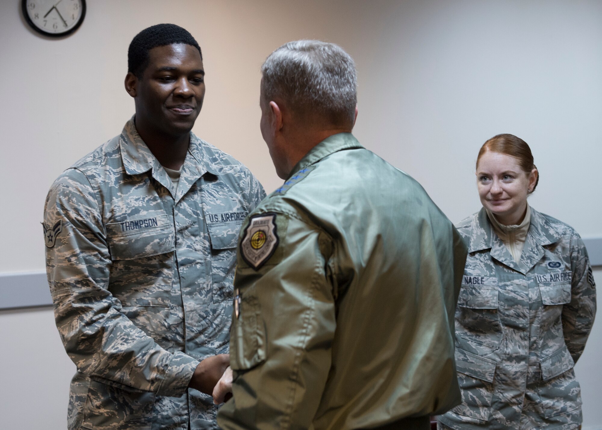 U.S. Air Force Airman 1st Class Octavius Thompson receives a coin from U.S. Air Force Gen. Tod D. Wolters.