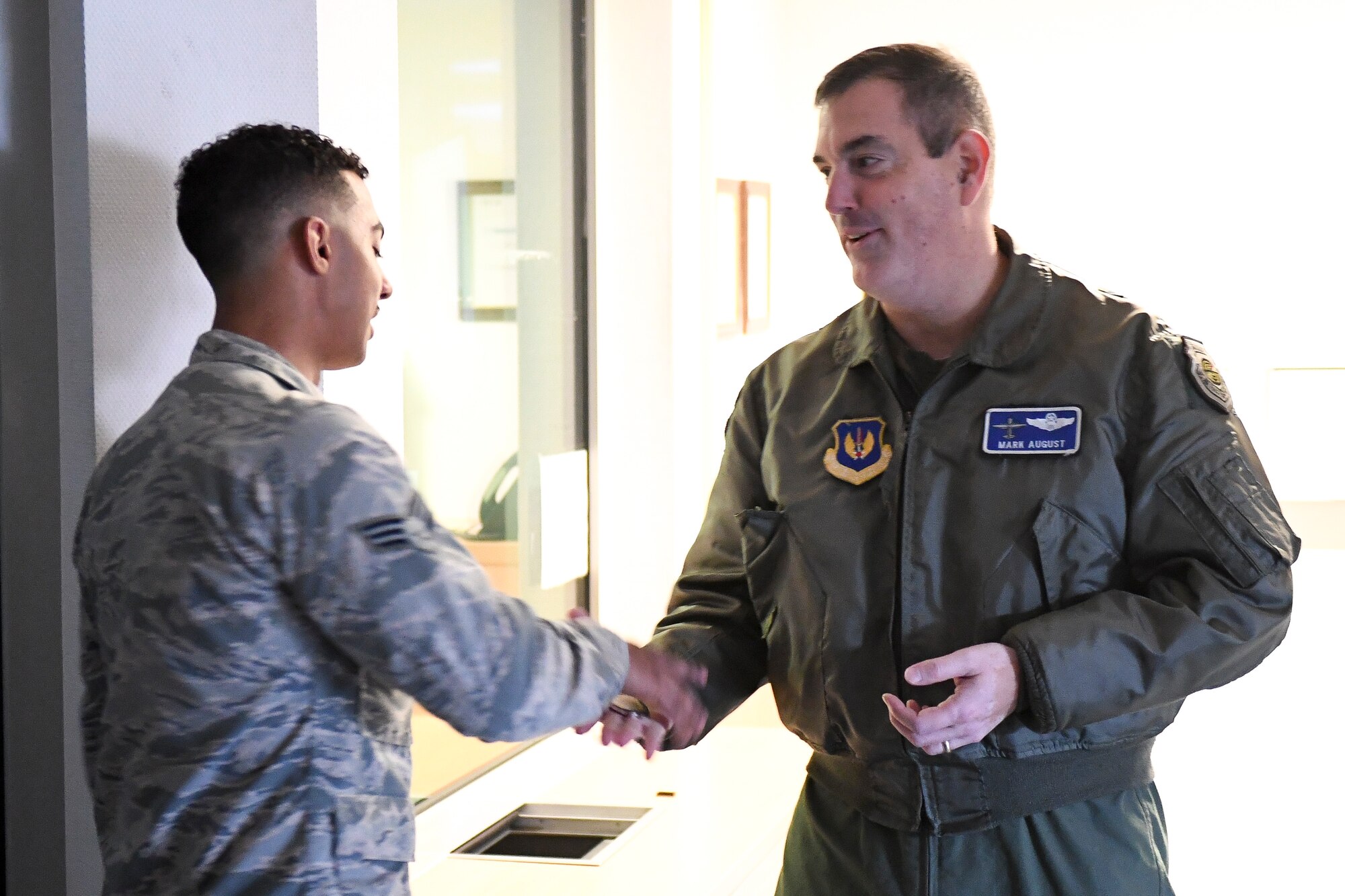 U.S. Air Force Brig. Gen. Mark R. August, 86th Airlift Wing commander, presents a coin to U.S. Air Force Senior Airman Cadairo Domino, 86th Security Forces Squadron installation patrolman, on Ramstein Air Base, Germany, Dec. 6, 2018. Domino received the honor of being Ramstein’s Airlifter of the Week for assisting a pregnant mother through active labor during entry controller duties in late October. (U.S. Air Force photo by Staff Sgt. Devin Boyer)