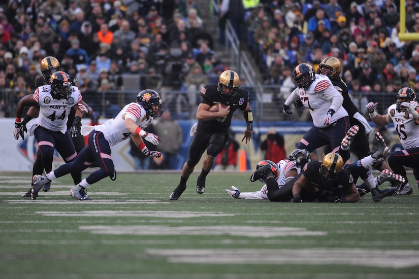 A football player runs with the ball.