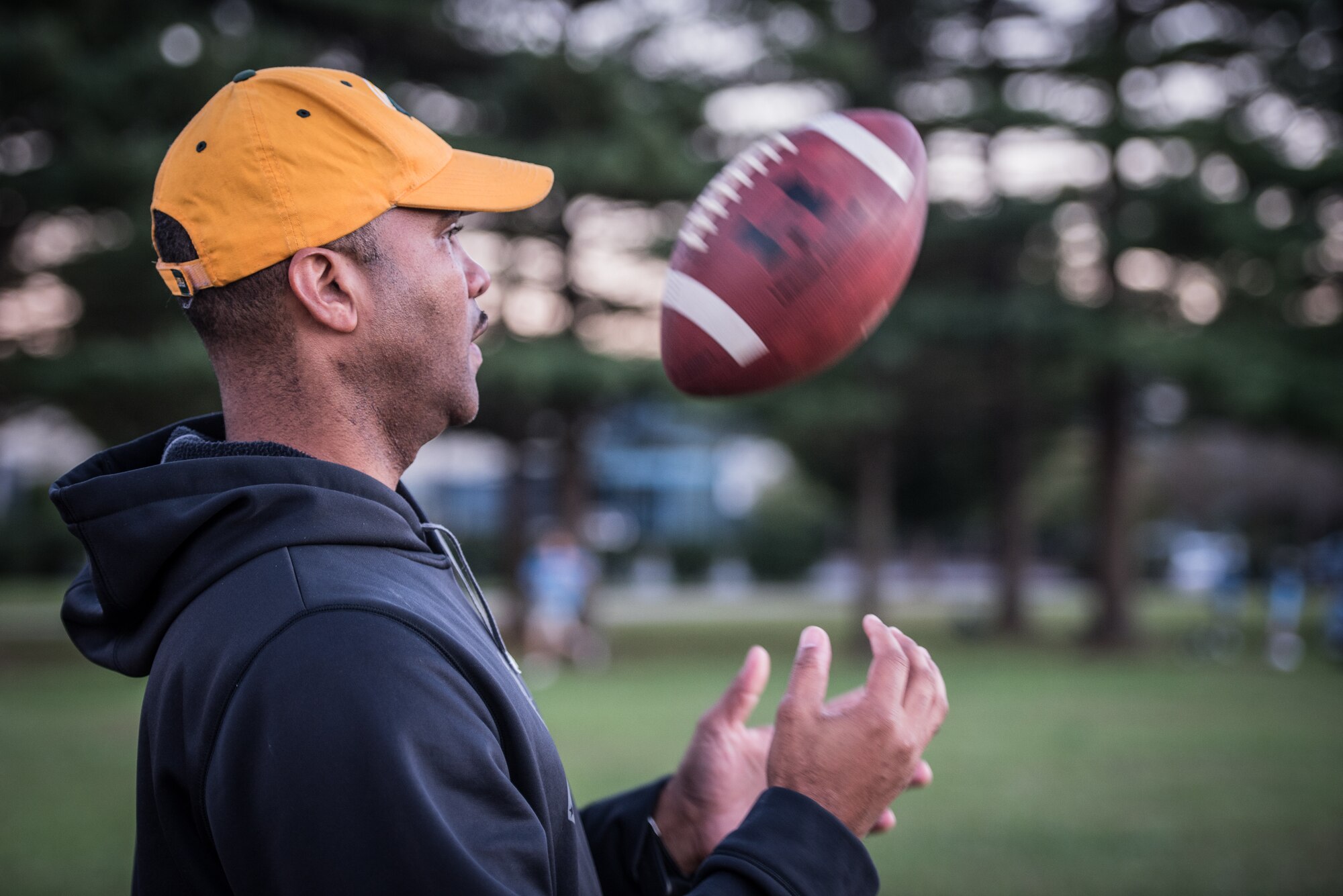 Chief Master Sgt. Anthony Harris, 512 Airlift Wing Force Support Squadron superintendent, tosses a football in Dover, Delaware, Oct. 18, 2018. Harris coaches The Pop Warner Dover Caesar Rodney Raiders peewee league team. (U.S. Air Force photo by Staff Sgt. Damien Taylor)