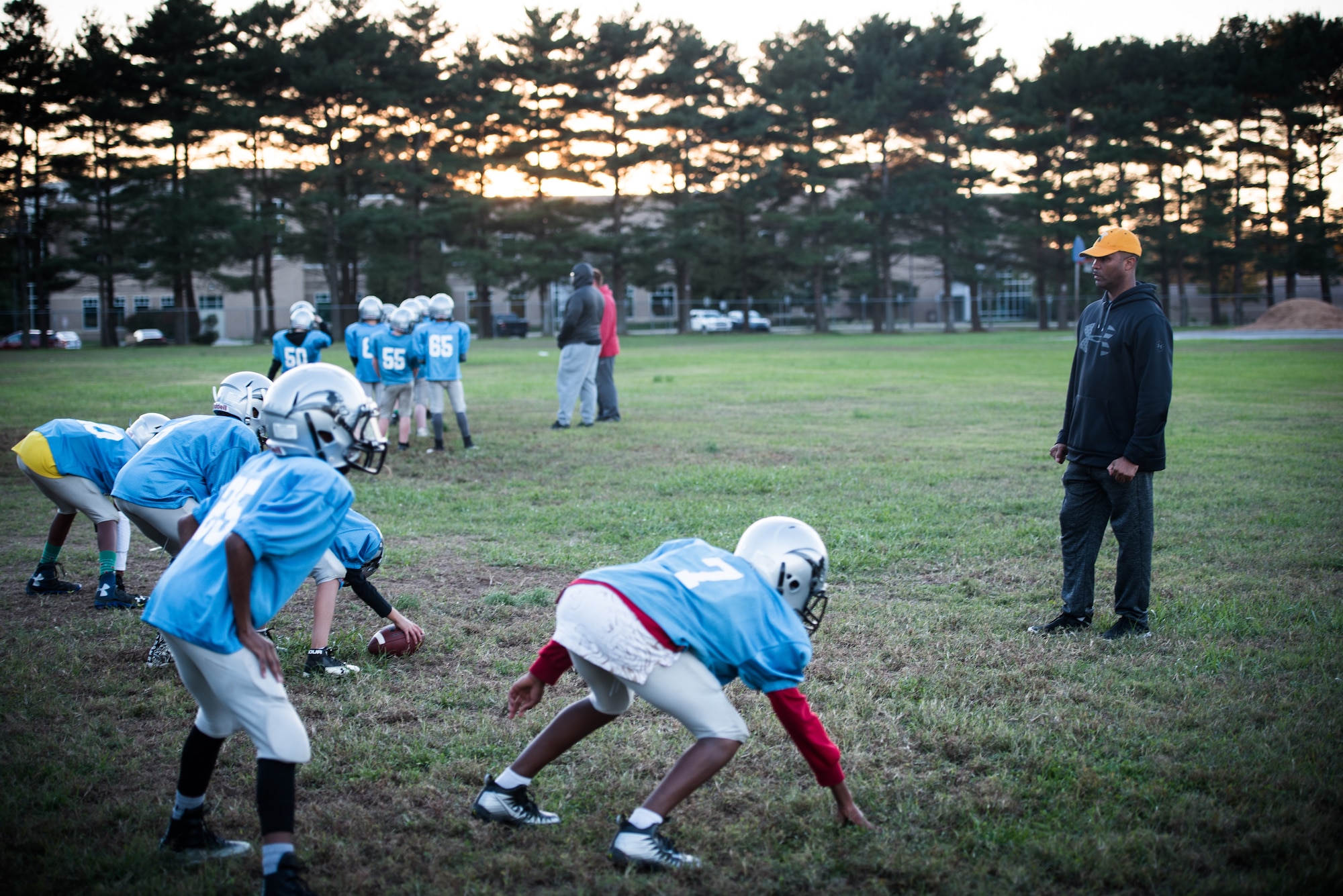 Chief Master Sgt. Anthony Harris, 512 Airlift Wing Force Support Squadron superintendent, drills four peewee league football players in Dover, Delaware, Oct. 18, 2018. Harris was the secondary defensive coach for the Pop Warner Dover Caesar Rodney Raiders during the four-month 2018 season. (U.S. Air Force photo by Staff Sgt. Damien Taylor)