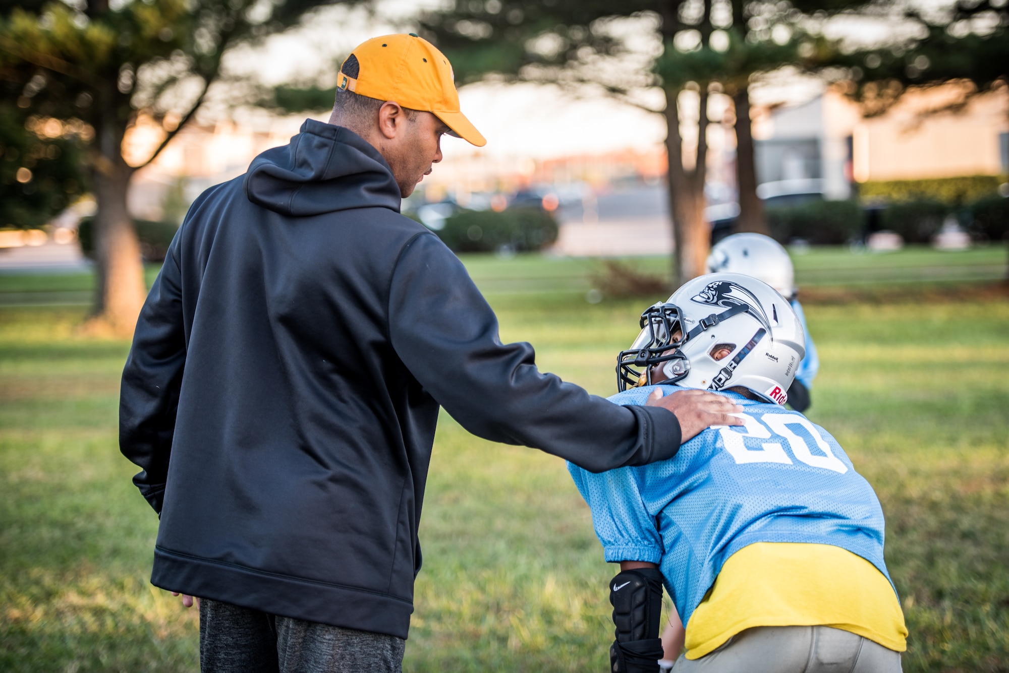 Chief Master Sgt. Anthony Harris, 512 Airlift Wing Force Support Squadron superintendent, sets a hand on his son, Anthony’s, shoulder on a field in Dover, Delaware, Oct. 18, 2018. Harris has coached his son as a Pop Warner Dover Caesar Rodney Raider from 2016 - 2018. (U.S. Air Force photo by Staff Sgt. Damien Taylor)