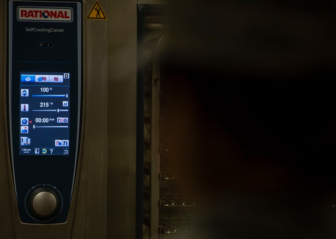 A U.S. Airman assigned to the 20th Force Support Squadron Emerson E. Williams Dining Facility looks at the touchscreen interface of a Rational Self-Cooking Center at Shaw Air Force Base, S.C., Dec. 4, 2018.