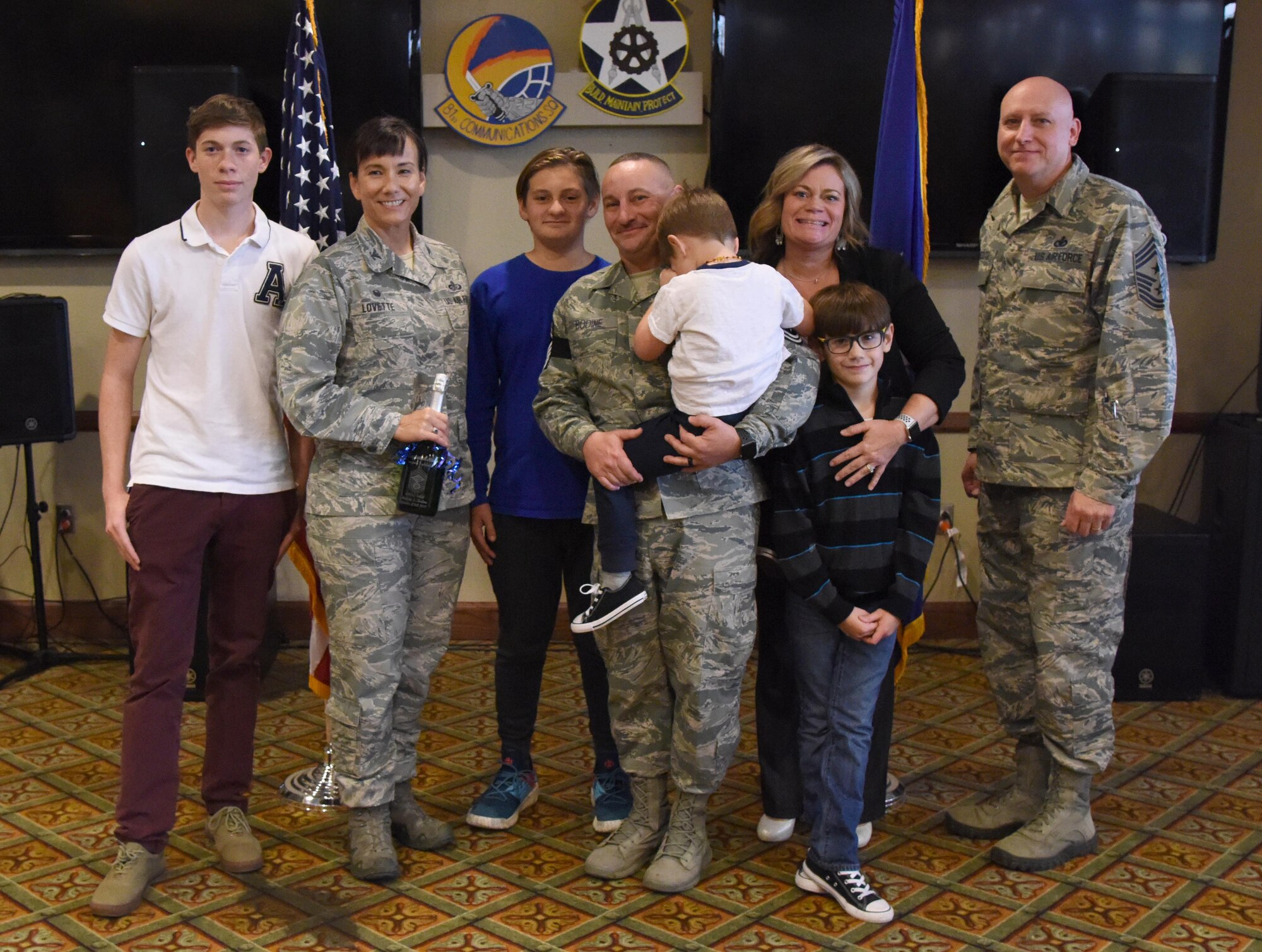 U.S. Air Force Col. Debra Lovette, 81st Training Wing commander, and Chief Master Sgt. David Pizzuto, 81st TRW command chief, presents Senior Master Sgt. Andrew Bodine, 81st Training Group military training superintendent, and his family with a memento for his promotion to the rank of chief master sergeant at Keesler Air Force Base, Mississippi, Dec. 6, 2018. Five senior master sgts. at Keesler were selected for promotion. (U.S. Air Force photo by Kemberly Groue)