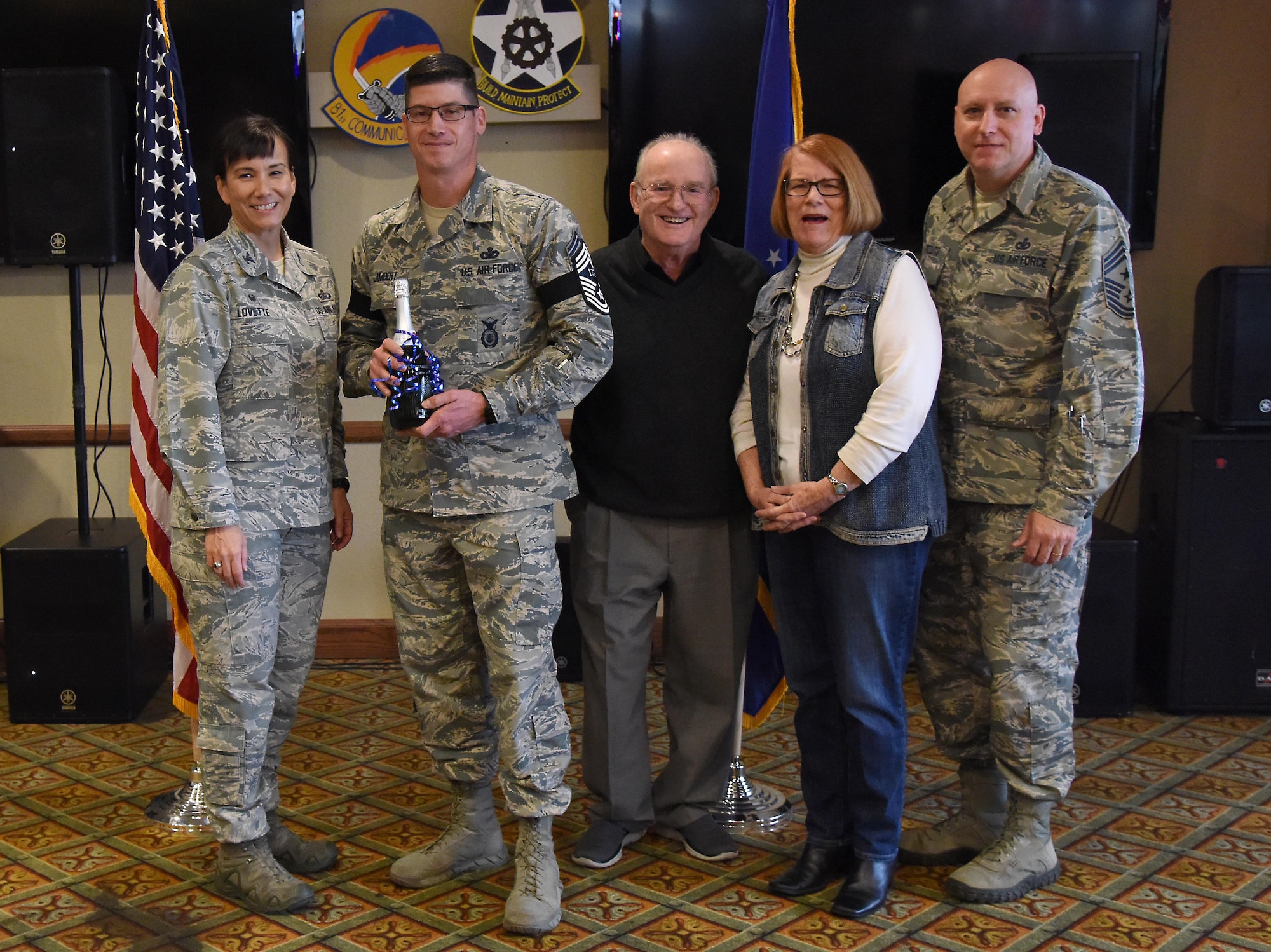 U.S. Air Force Col. Debra Lovette, 81st Training Wing commander, and Chief Master Sgt. David Pizzuto, 81st TRW command chief, present Senior Master Sgt. Kevin Lambert, 81st Security Forces Squadron operations superintendent, and his family with a memento for his promotion to the rank of chief master sergeant at Keesler Air Force Base, Mississippi, Dec. 6, 2018. Five senior master sgts. at Keesler were selected for promotion. (U.S. Air Force photo by Kemberly Groue)