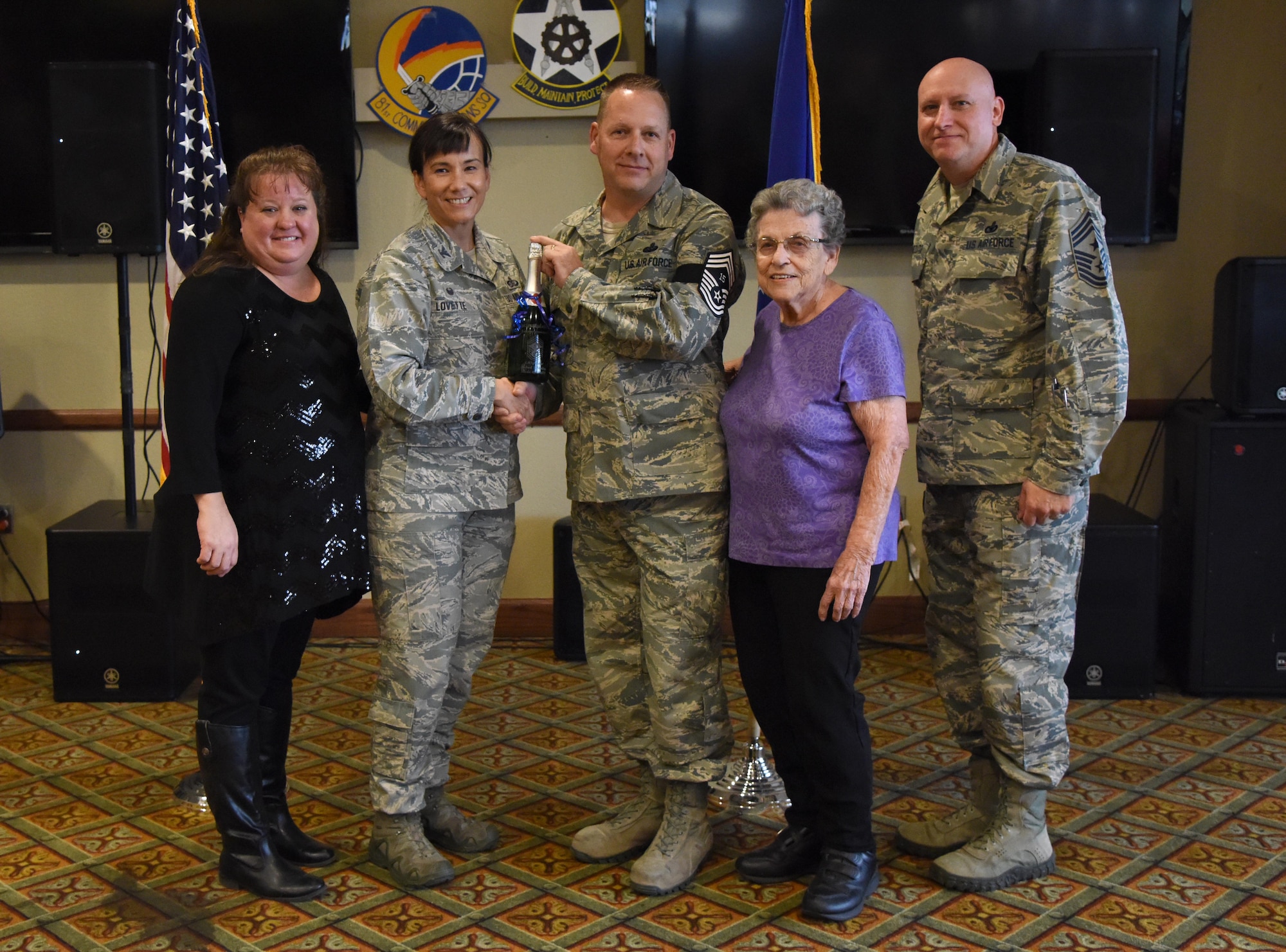 U.S. Air Force Col. Debra Lovette, 81st Training Wing commander, and Chief Master Sgt. David Pizzuto, 81st TRW command chief, present Senior Master Sgt. Michael Sterling, 81st Communications Squadron superintendent, and his family with a memento for his promotion to the rank of chief master sergeant at Keesler Air Force Base, Mississippi, Dec. 6, 2018. Five senior master sgts. at Keesler were selected for promotion. (U.S. Air Force photo by Kemberly Groue)