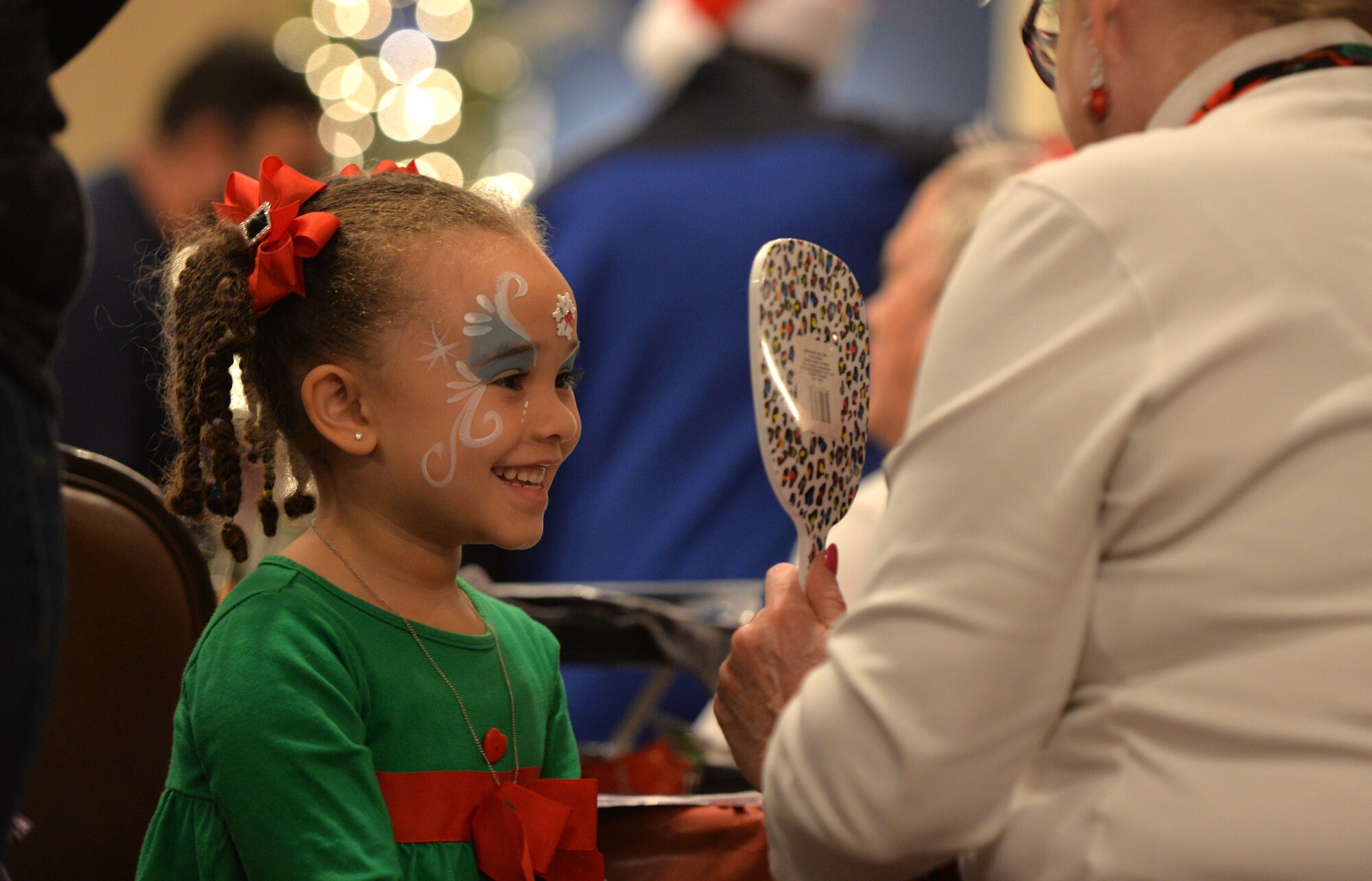Four-year-old Gabriella, daughter of Staff Sgt. Kevin Richardson, 55th Strategic Communication Squadron, looks at her reflection during the Offutt Christmas Tree Lighting event at the Patriot Club, Offutt Air Force Base, Nebraska, Dec. 6, 2018. The ceremony included a meet and greet with Mr. and Mrs. Claus, live music, dinner, bingo and an “Elf Mart” where children had a chance to shop for their parents. (U.S. Air Force photo by Josh Plueger)