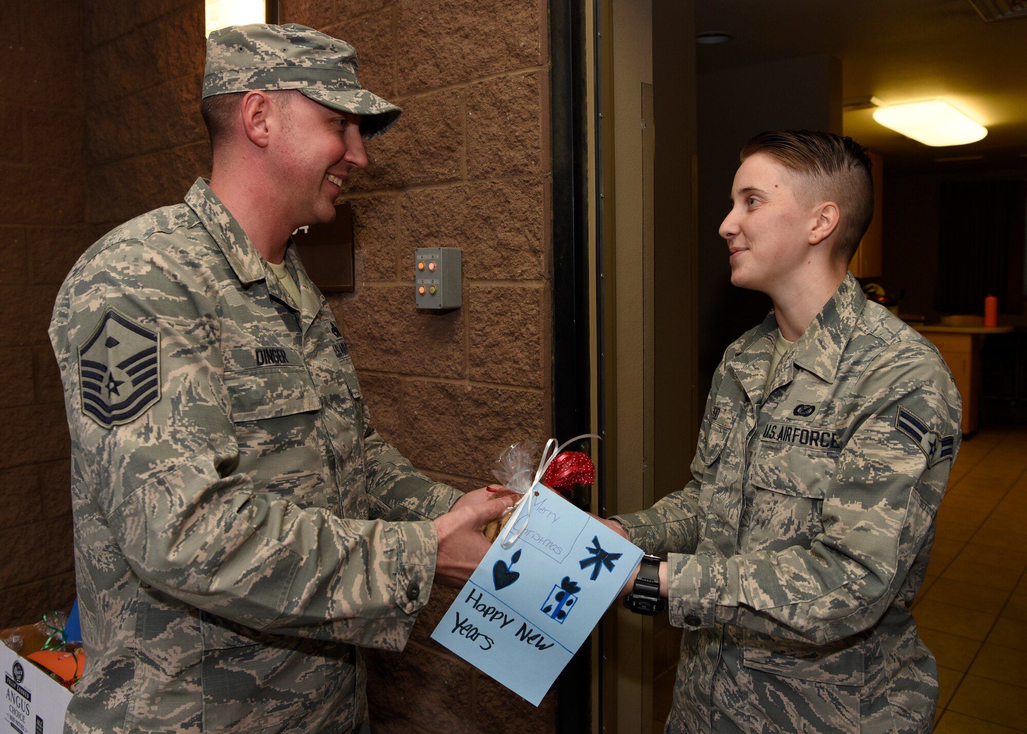 Master Sgt. Joshua Dinger, 56th Fighter Wing Staff Agencies First Sergeant, delivers cookies to a dorm resident, Dec. 6, 2018, at Luke Air Force Base, Ariz.