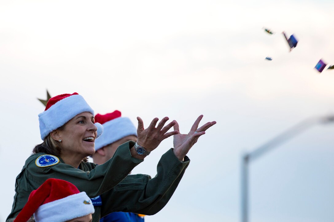 Col. Jennifer Short, 23d Wing commander, tosses candy to attendees during the Tree Lighting Ceremony, Nov. 30, 2018, at Moody Air Force Base, Ga. The event continues the tradition of families of deployed Airmen lighting the base Christmas tree. As a way to celebrate the sacrifices of Team Moody Airmen and their families, the base also hosted a parade and other holiday festivities. (U.S. Air Force photo by Airman 1st Class Erick Requadt)