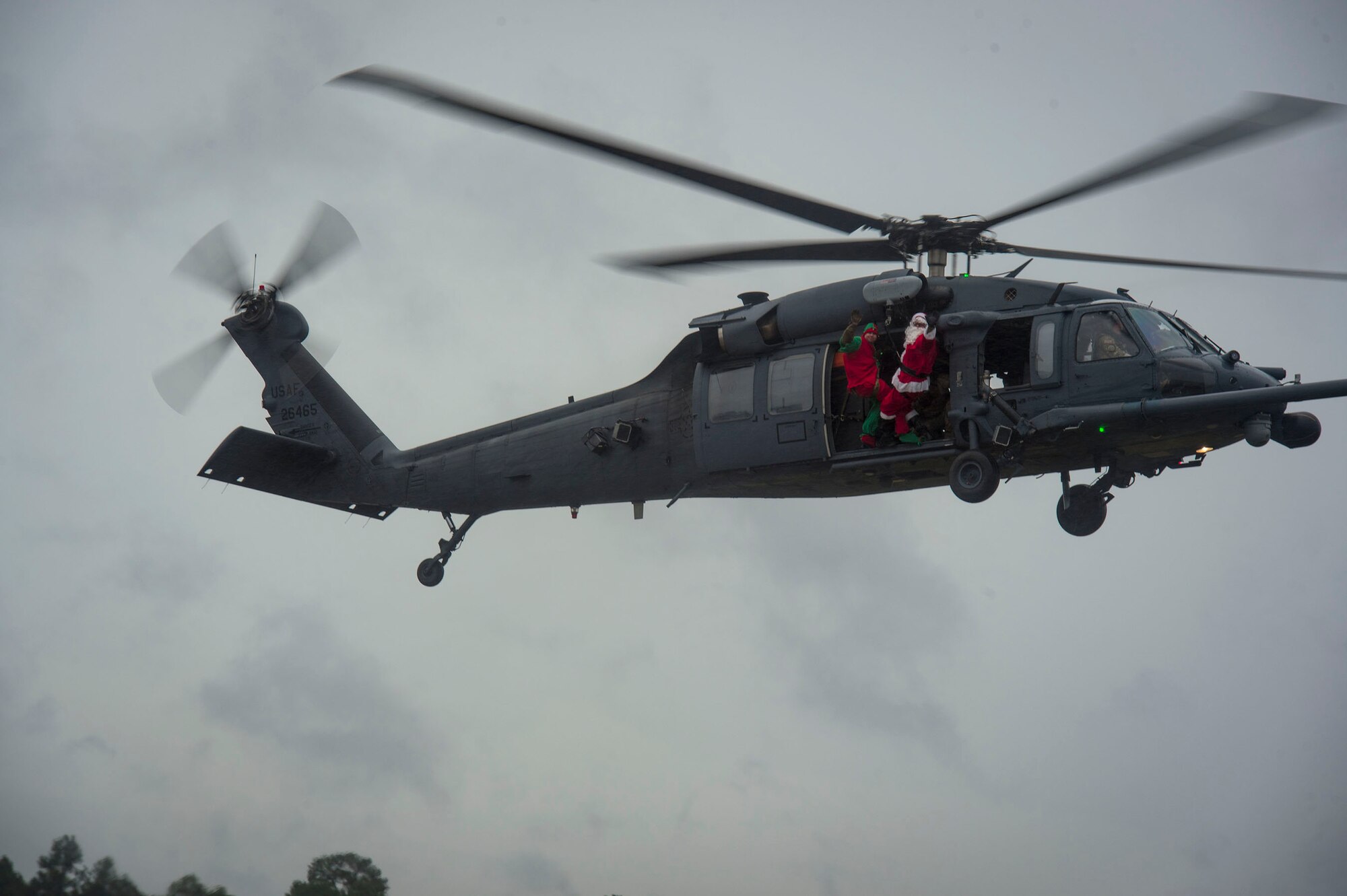 Santa and his elf waves to a crowd below during the 347th Rescue Group and 23d Maintenance Group Children’s Christmas Party, Dec. 1, 2018, at Moody Air Force Base, Ga. Airmen and their families enjoyed the holiday festivities by taking photos with Santa, face painting and playing games. (U.S. Air Force photo by Senior Airman Gregory Nash)