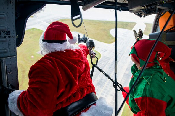 Santa and his elf waves to a crowd below during the 347th Rescue Group and 23d Maintenance Group Children’s Christmas Party, Dec. 1, 2018, at Moody Air Force Base, Ga. Airmen and their families enjoyed the holiday festivities by taking photos with Santa, face painting and playing games. (U.S. Air Force photo by Airman 1st Class Erick Requadt)