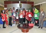 Group of festively-dressed people pose around table.