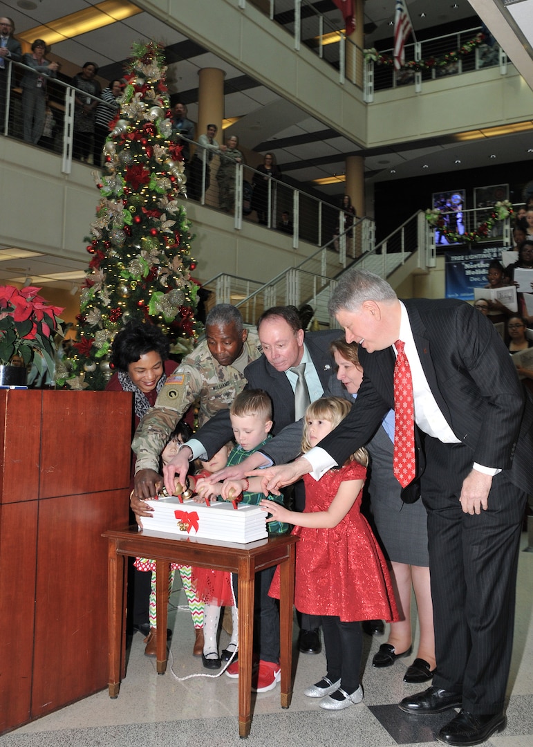 two women, three men and two children prepare to light the Christmas tree at the annual Christmas tree lighting ceremony.