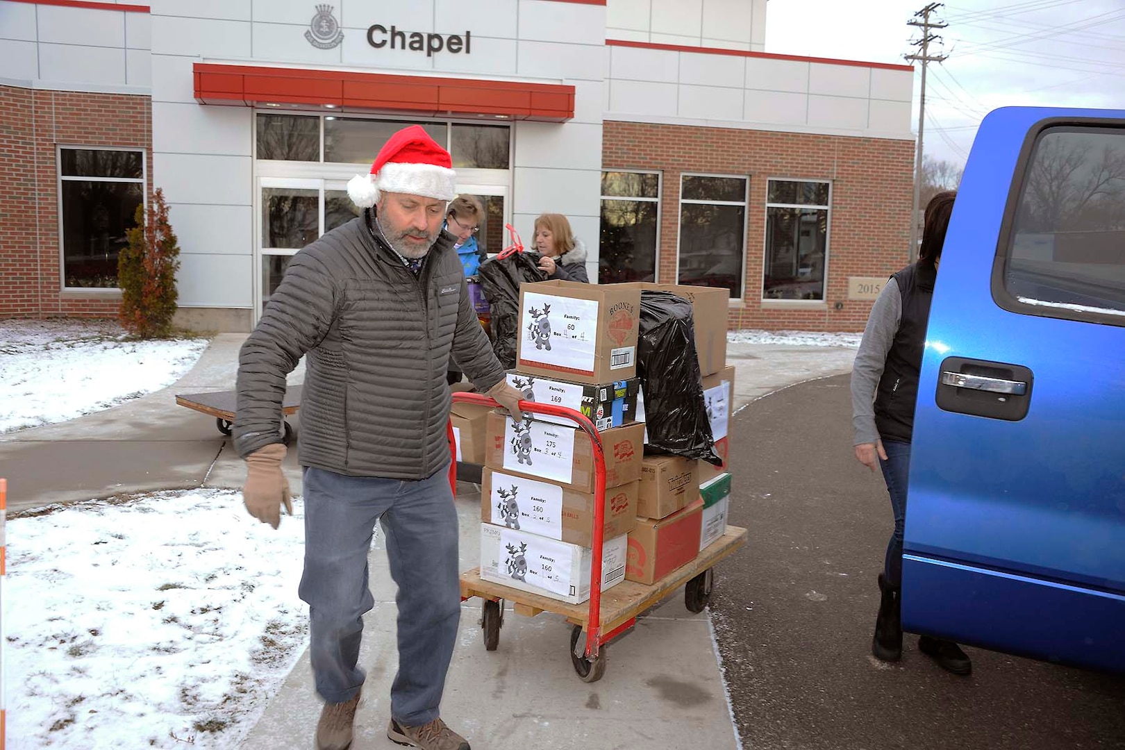 Don Phillips, DLA Installation Support at Battle Creek site director, pulls a cart full of donated items into the Salvation Army facility.