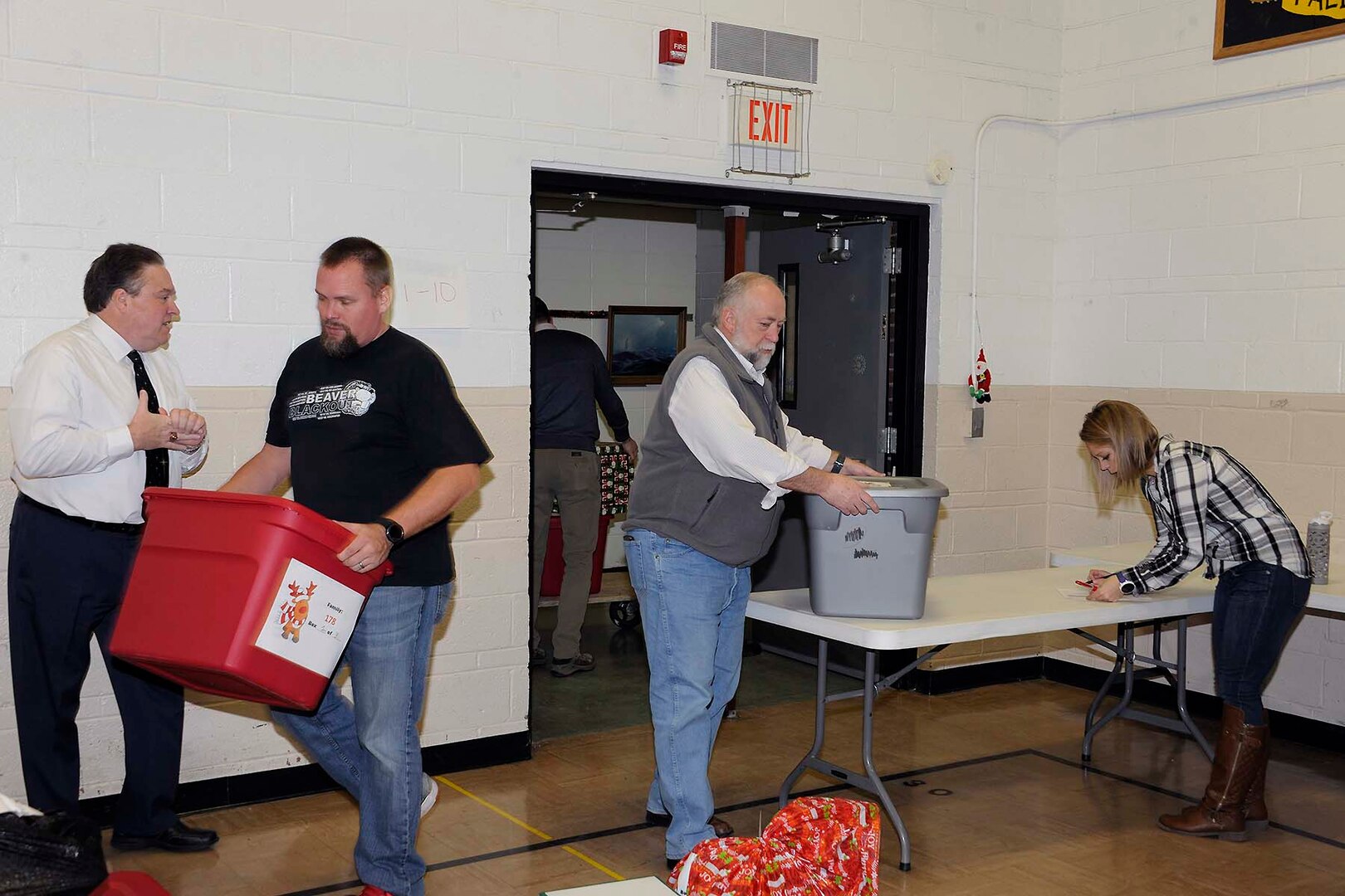 Ray Zingaretti (far left), Logistics Information Services director; Mike Schmidt (left center), volunteer,  Kevin Faber (right center), local DLA Information Operations “mayor;” and LeAnn Gaviglio, delivery and volunteer coordinator, check in items and move them to the staging area.