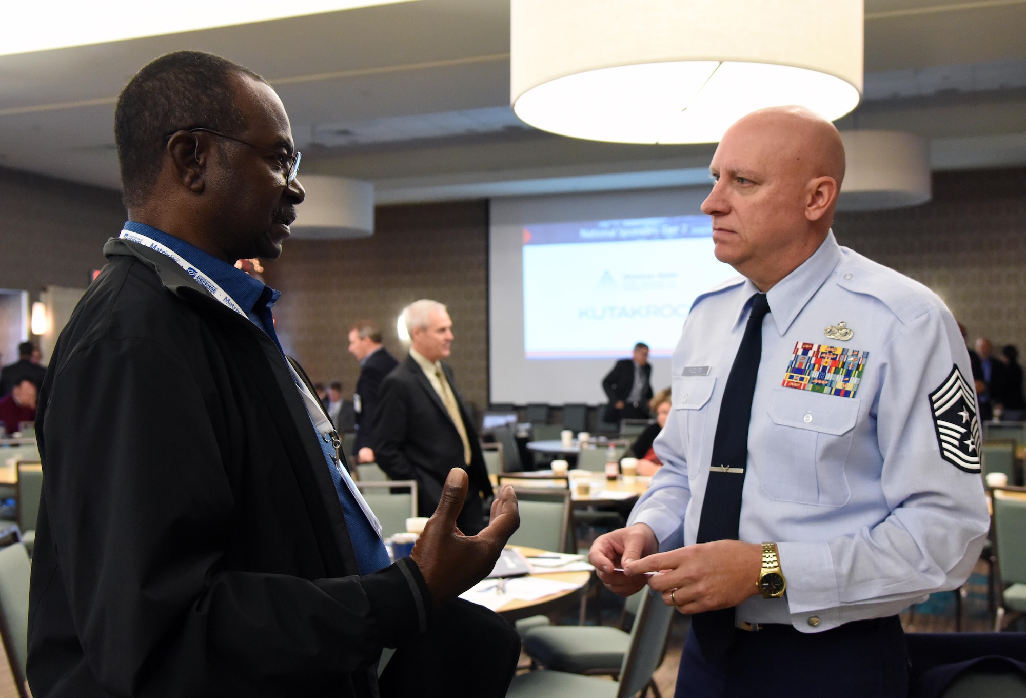 U.S. Air Force Chief Master Sgt. David Pizzuto, 81st Training Wing command chief, engages in discussion with Jeff Moore, SCORE certified mentor, during the Mississippi Gulf Coast Defense Forum inside the Courtyard by Marriott Gulfport Beachfront in Gulfport, Mississippi, Dec. 4, 2018. Over 130 people were in attendance over the two-day event, where participants gained a greater understanding of our military capabilities and opportunities in Mississippi. (U.S. Air Force photo by Kemberly Groue)