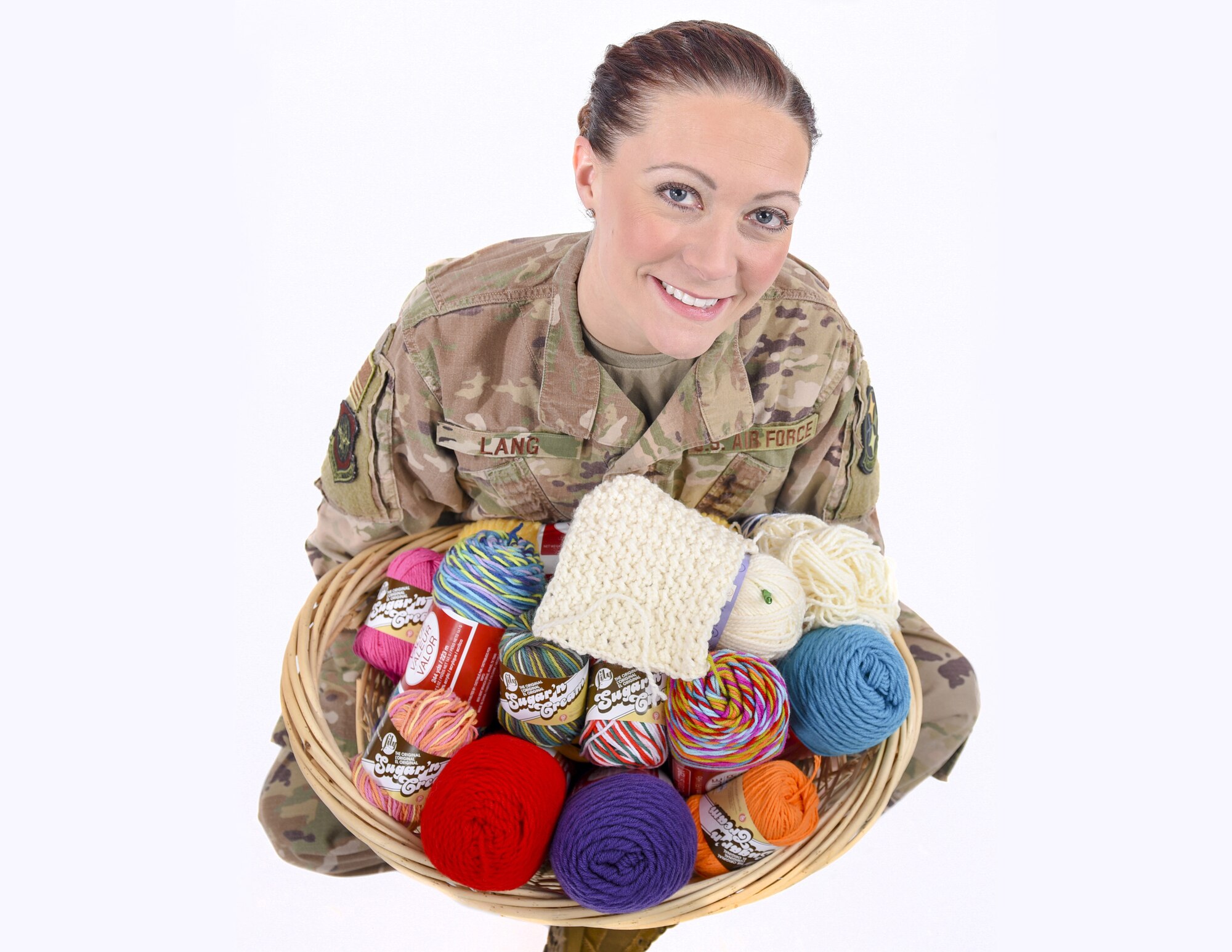 Tech. Sgt. Amber Lang poses for a photo holding a basket of yarn.
