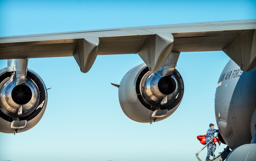 A Royal Australian Air Force airman carries supplies into a C-17 Globemaster III at Luke Air Force Base, Ariz., Dec. 3, 2018. The RAAF loaded the aircraft with airmen and supplies in preparation for their multi-day journey to Australia. The Globemaster is scheduled to follow two F-35A Lightning II’s for their historic arrival in Australia. (U.S. Air Force photo by Staff Sgt. Jensen Stidham)