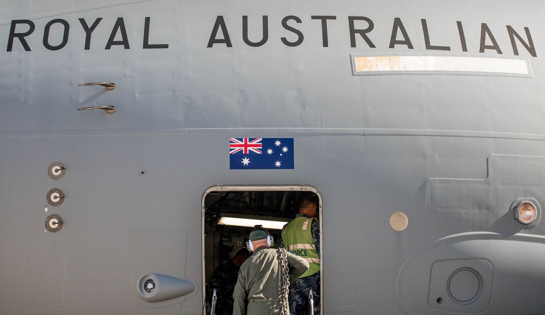 A Royal Australian Air Force airman carries supplies into a C-17 Globemaster III at Luke Air Force Base, Ariz., Dec. 3, 2018. The RAAF loaded the aircraft with airmen and supplies in preparation for their multi-day journey to Australia. The Globemaster is scheduled to follow two F-35A Lightning II’s for their historic arrival in Australia. (U.S. Air Force photo by Staff Sgt. Jensen Stidham)