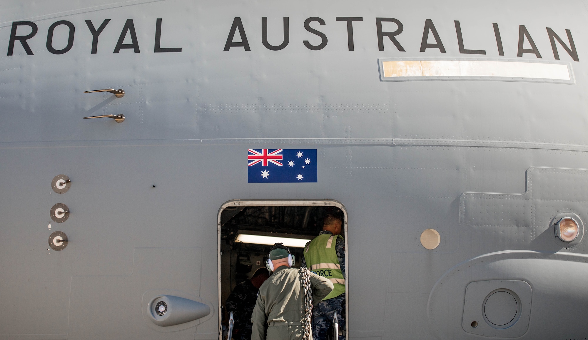 A Royal Australian Air Force airman carries supplies into a C-17 Globemaster III at Luke Air Force Base, Ariz., Dec. 3, 2018. The RAAF loaded the aircraft with airmen and supplies in preparation for their multi-day journey to Australia. The Globemaster is scheduled to follow two F-35A Lightning II’s for their historic arrival in Australia. (U.S. Air Force photo by Staff Sgt. Jensen Stidham)