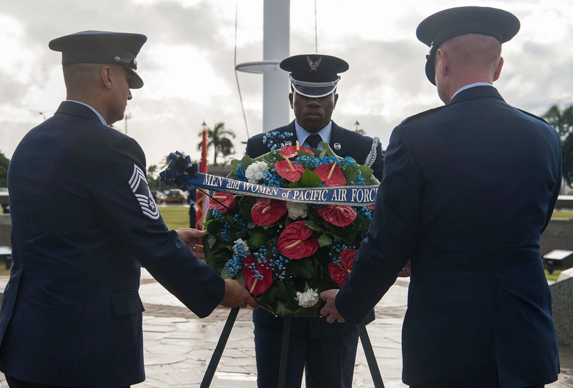 Chief Master Sgt. Carlos Rosa, 647th Air Base Group superintendent, and Col. Halsey Burks, 15th Wing commander, lay a wreath on behalf of the men and women of Pacific Air Forces at the flag pole during the Hickam Field Dec. 7th Remembrance Ceremony at Atterbury Circle, Joint Base Pearl Harbor-Hickam, Hawaii, Dec. 7, 2018. The flag pole was bombed three times and strafed during the Dec. 7th attack, but never fell. Today, the flag pole stands as a tribute to those men who manned a .50-caliber water-cooled machine gun at the base. (U.S. Air Force photo by Tech. Sgt. Heather Redman)