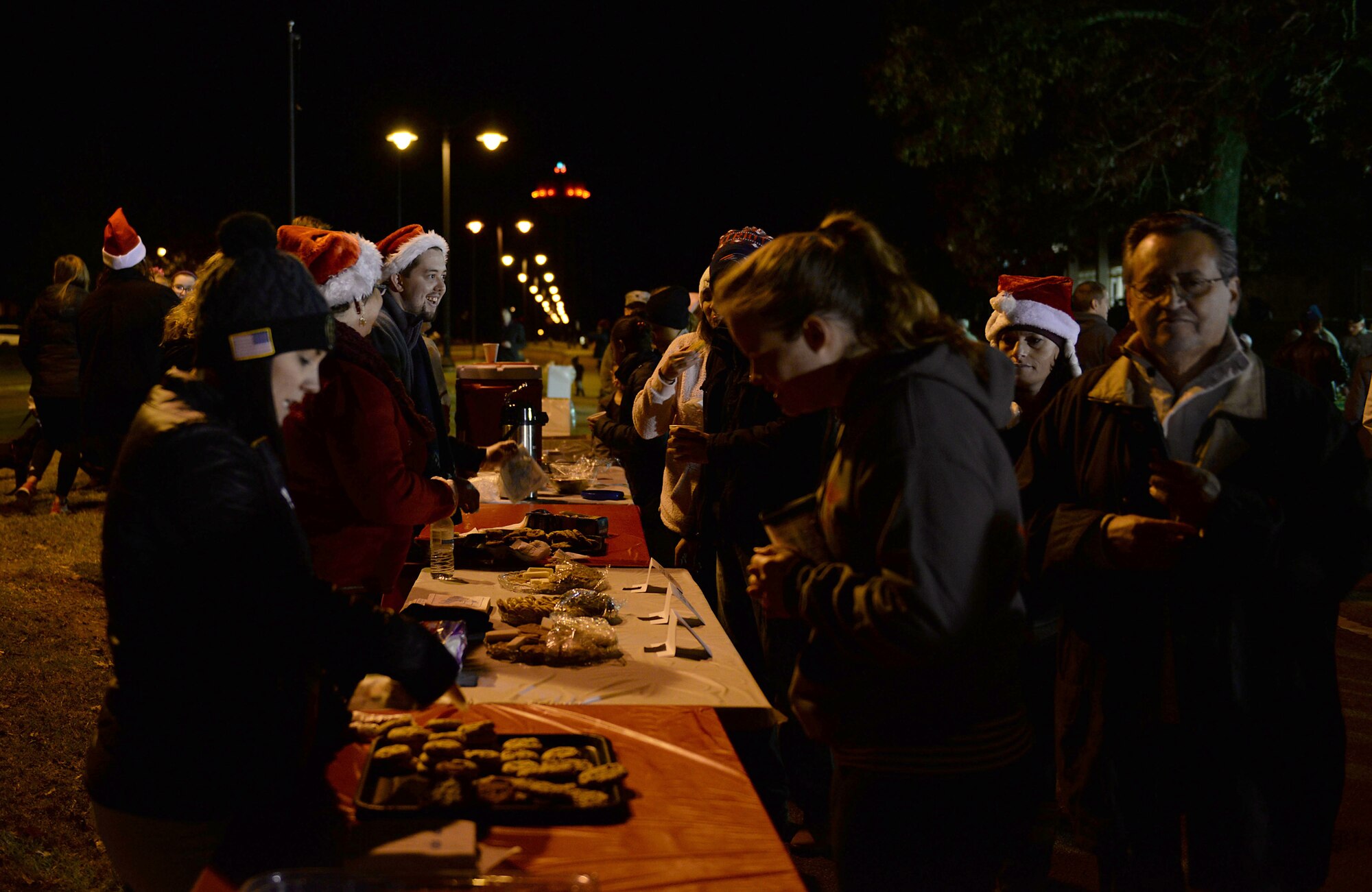 Team BLAZE members serve cookies to attendees during the Base Christmas Tree Lighting Dec. 4, 2018, at the BLAZE Chapel on Columbus Air Force Base, Mississippi. Cookies and drinks were provided by various base organizations, and the Caledonia High School Choir performed Christmas carols during the event. (U.S. Air Force photo by Airman Hannah Bean)