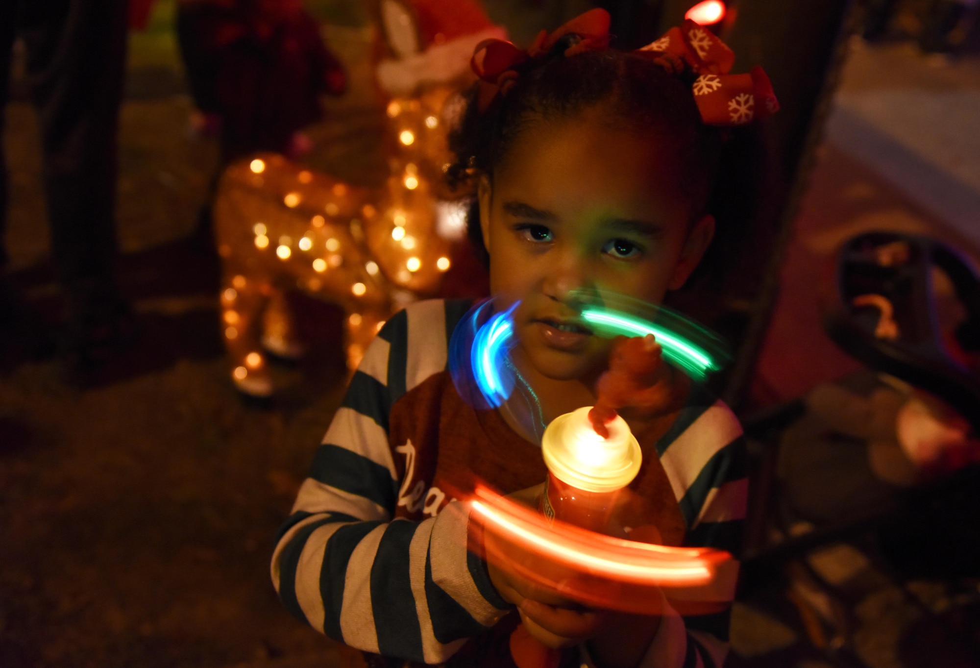 Avery Davis, granddaughter of U.S. Air Force Retired Master Sgt. Chad Jacob, plays with a light toy during Christmas in the Park at Keesler Air Force Base, Mississippi, Dec. 6, 2018. The event hosted by Outdoor Recreation included cookie and ornament decorating, games and visits with Santa. (U.S. Air Force photo by Kemberly Groue)