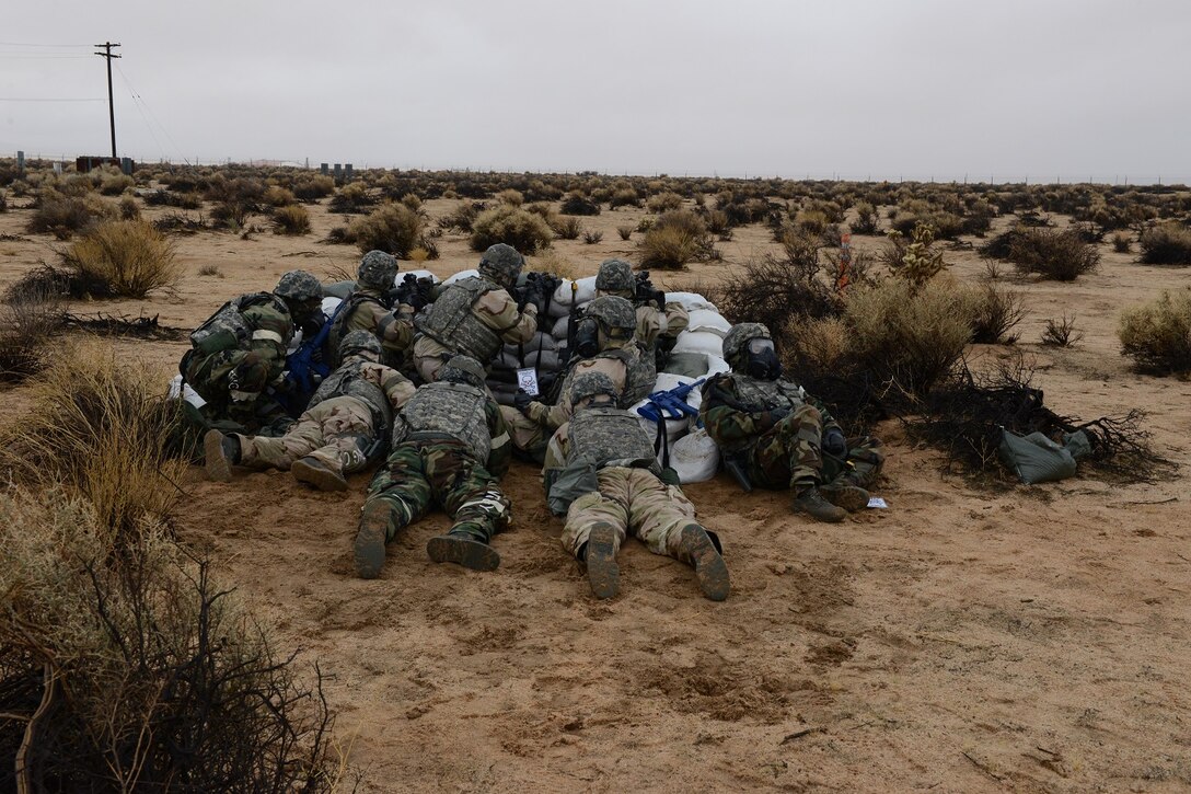 Airmen take cover and return fire during the latest readiness exercise Dec. 6 at North Base. Their mission was to protect their forward operating base in a far away country from enemy attack. (U.S. Air Force photo by Kenji Thuloweit)